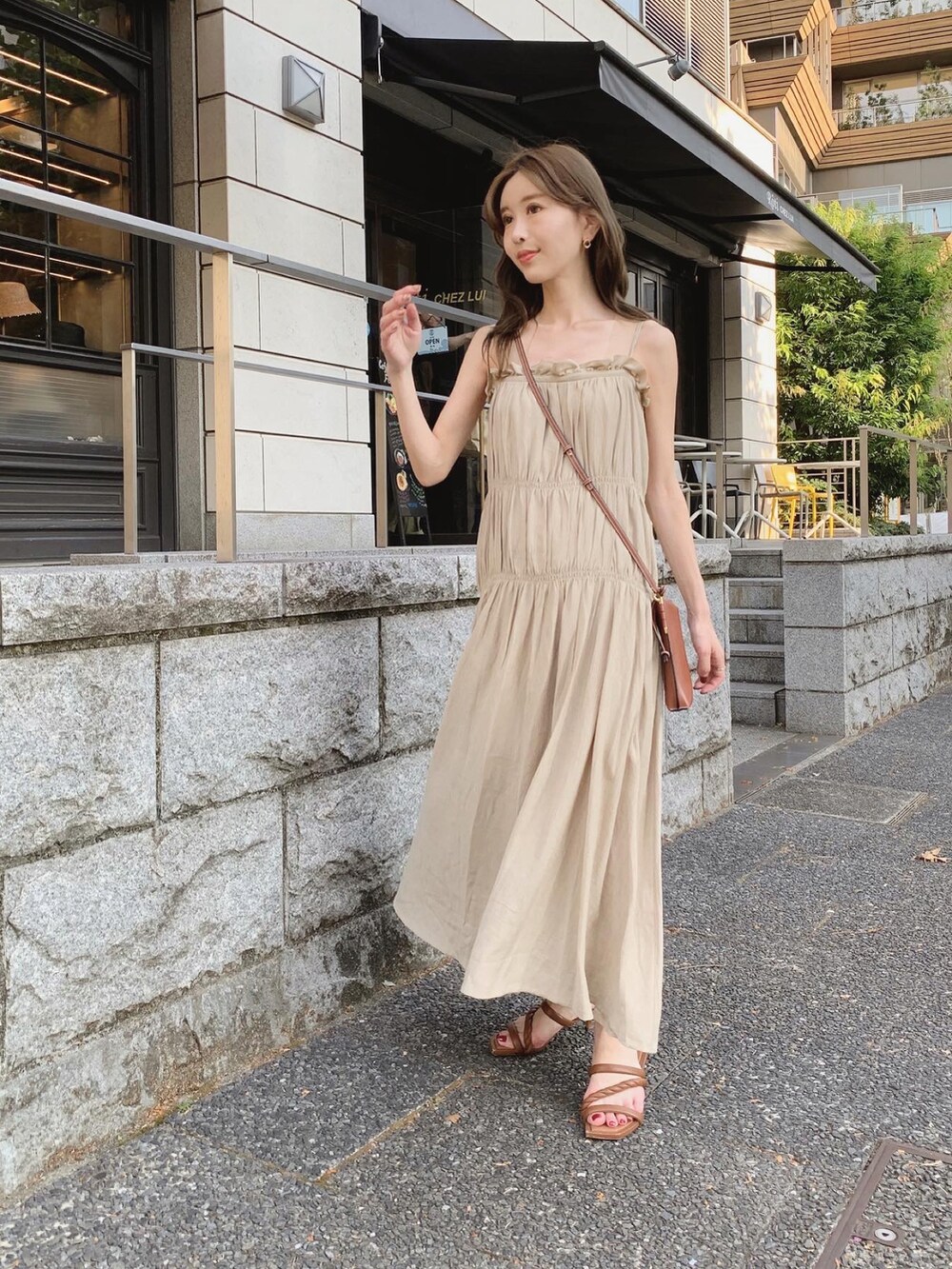 ベージュ系のワンピース、ブラウン系のショルダーバッグ、ブラウン系のサンダルを着用したレディースの夏コーディネートの3枚目の写真