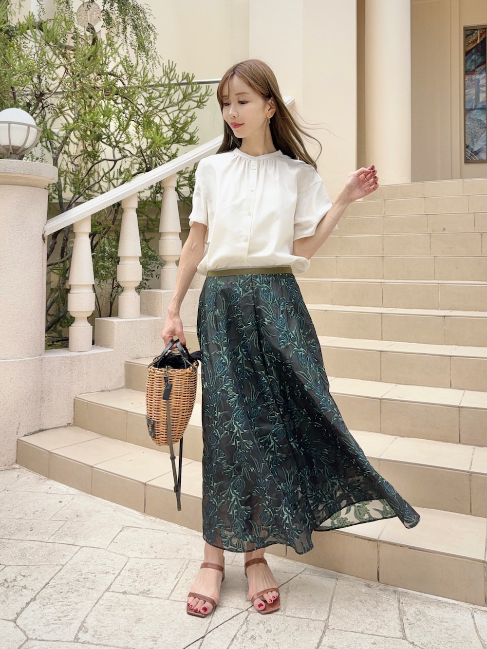 ホワイト系のシャツ/ブラウス、グリーン系のスカート、ベージュ系のバッグを着用したレディースの夏コーディネートの2枚目の写真