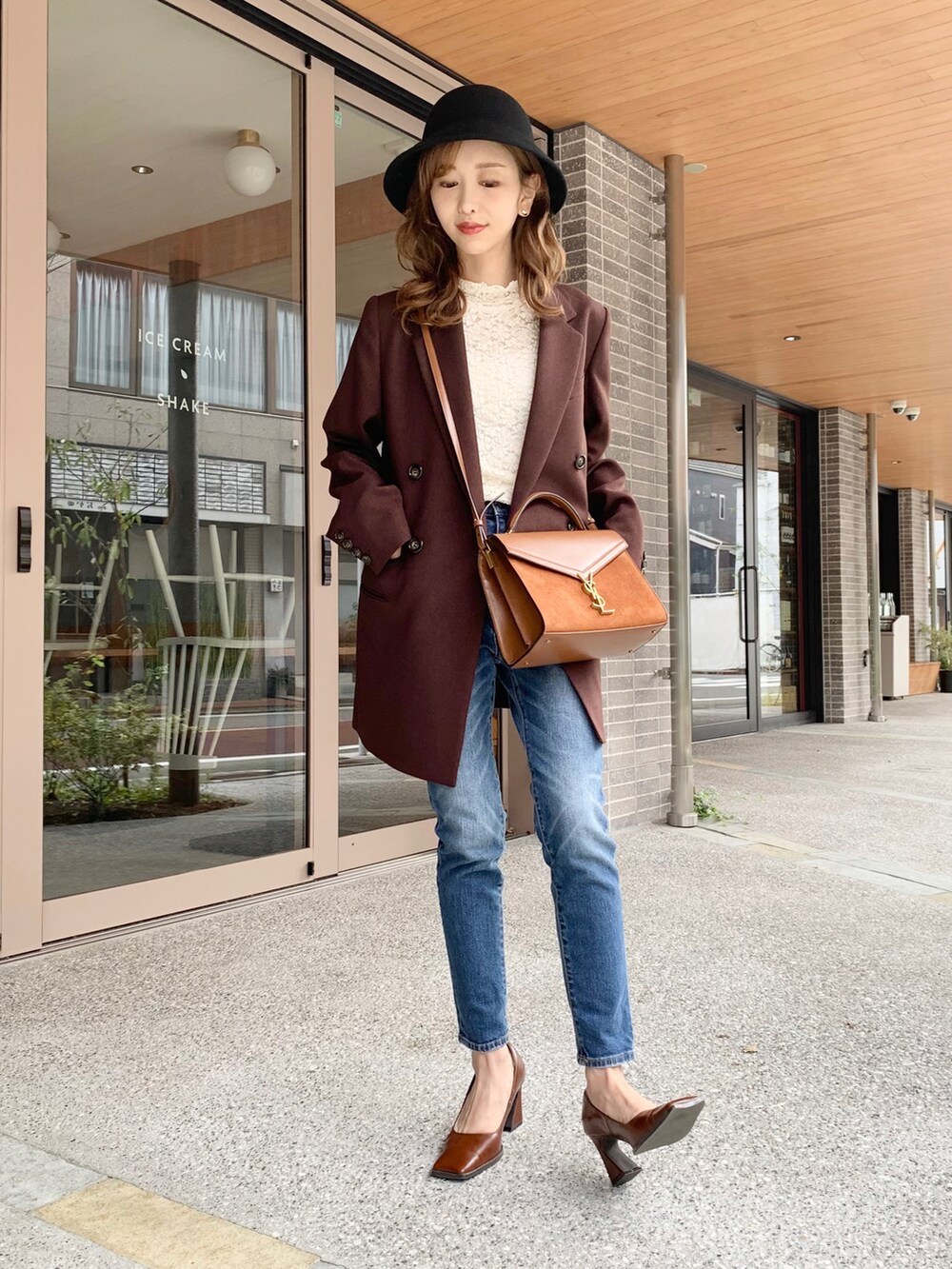 ブラウン系のテーラードジャケット、ホワイト系のTシャツ/カットソー、ブルー系のデニムパンツを着用したレディースの秋コーディネートの2枚目の写真