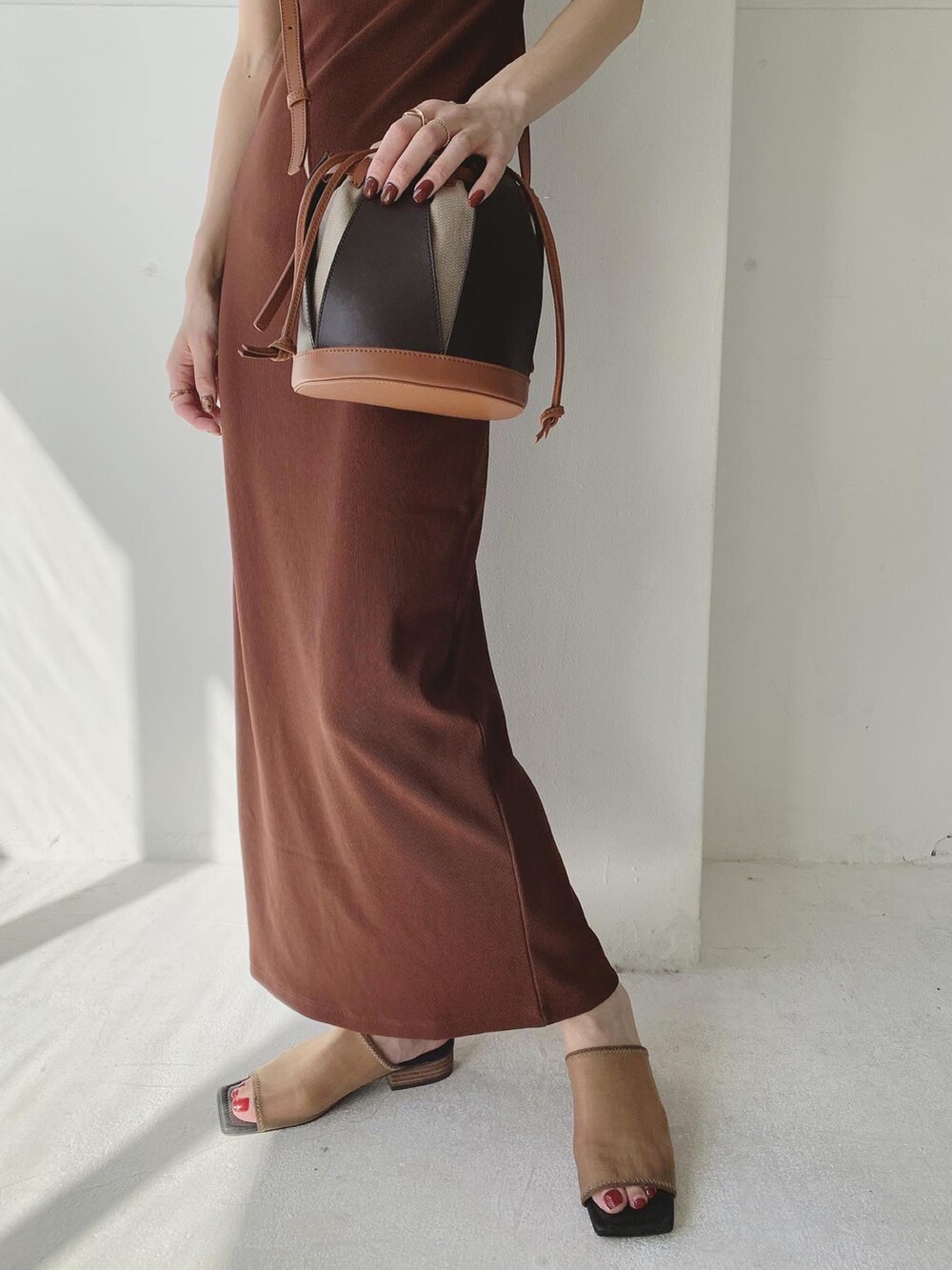 レッド系のワンピース、ブラウン系のショルダーバッグ、ブラウン系のサンダルを着用したレディースの夏コーディネートの3枚目の写真