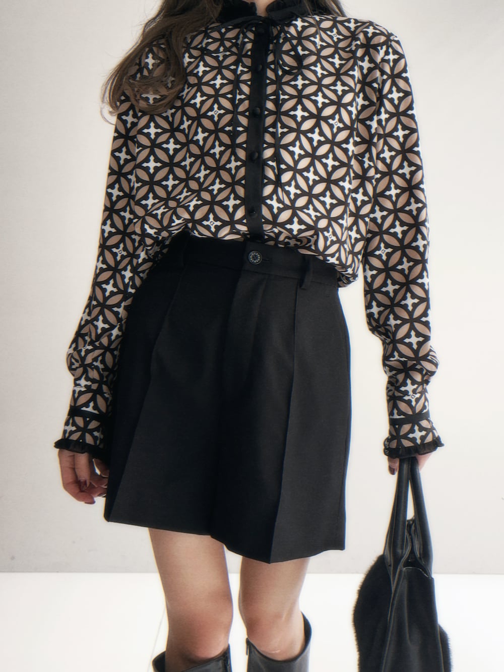 ブラック系のテーラードジャケット、ブラック系のその他パンツ、レッド系のショルダーバッグを着用したレディースの秋コーディネートの3枚目の写真