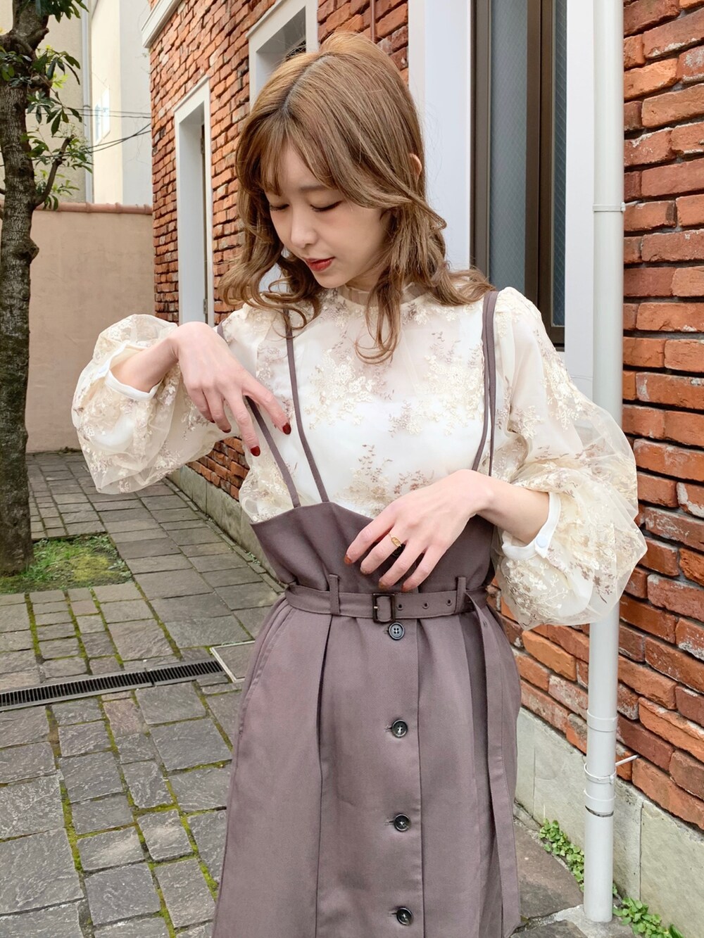 ブラウン系のスカート、ホワイト系のシャツ/ブラウスを着用したレディースの春コーディネートの3枚目の写真
