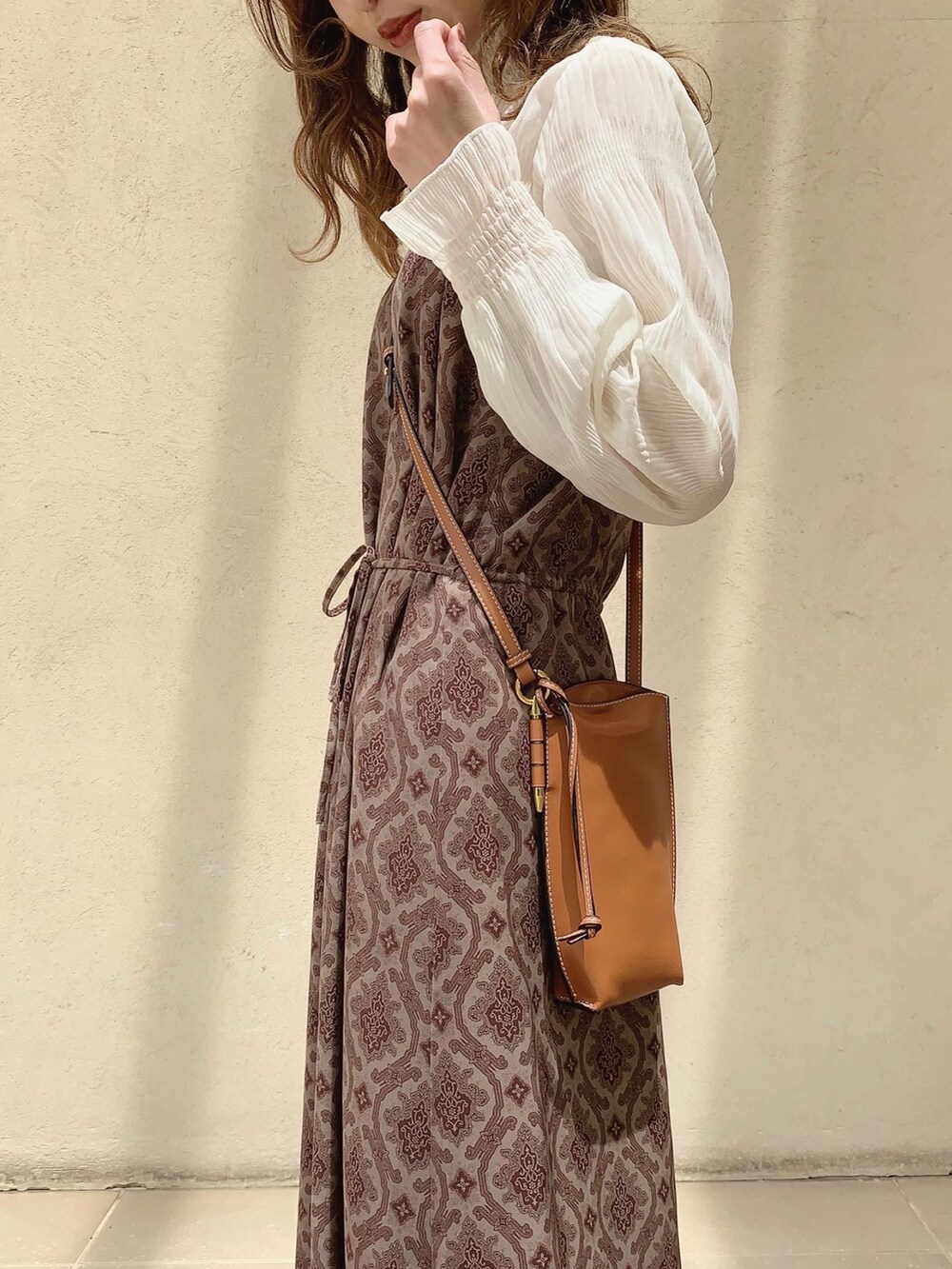 ブラウン系のバッグ、ブラウン系のワンピース、ブラック系のバレエシューズを着用したレディースの春コーディネートの3枚目の写真