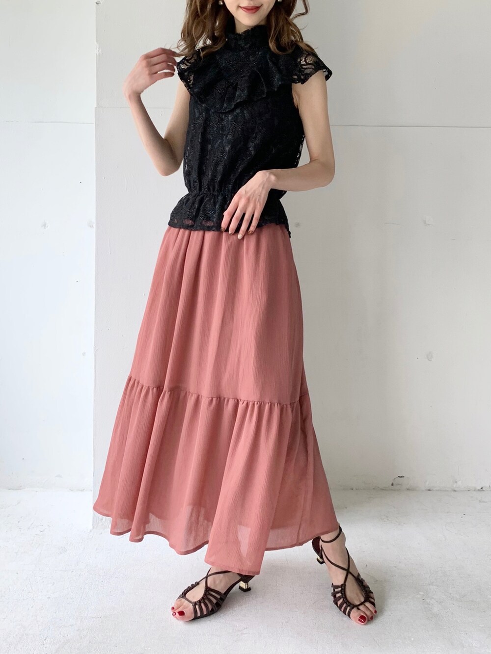 ブラック系のシャツ/ブラウス、ピンク系のスカートを着用したレディースの夏コーディネートの2枚目の写真