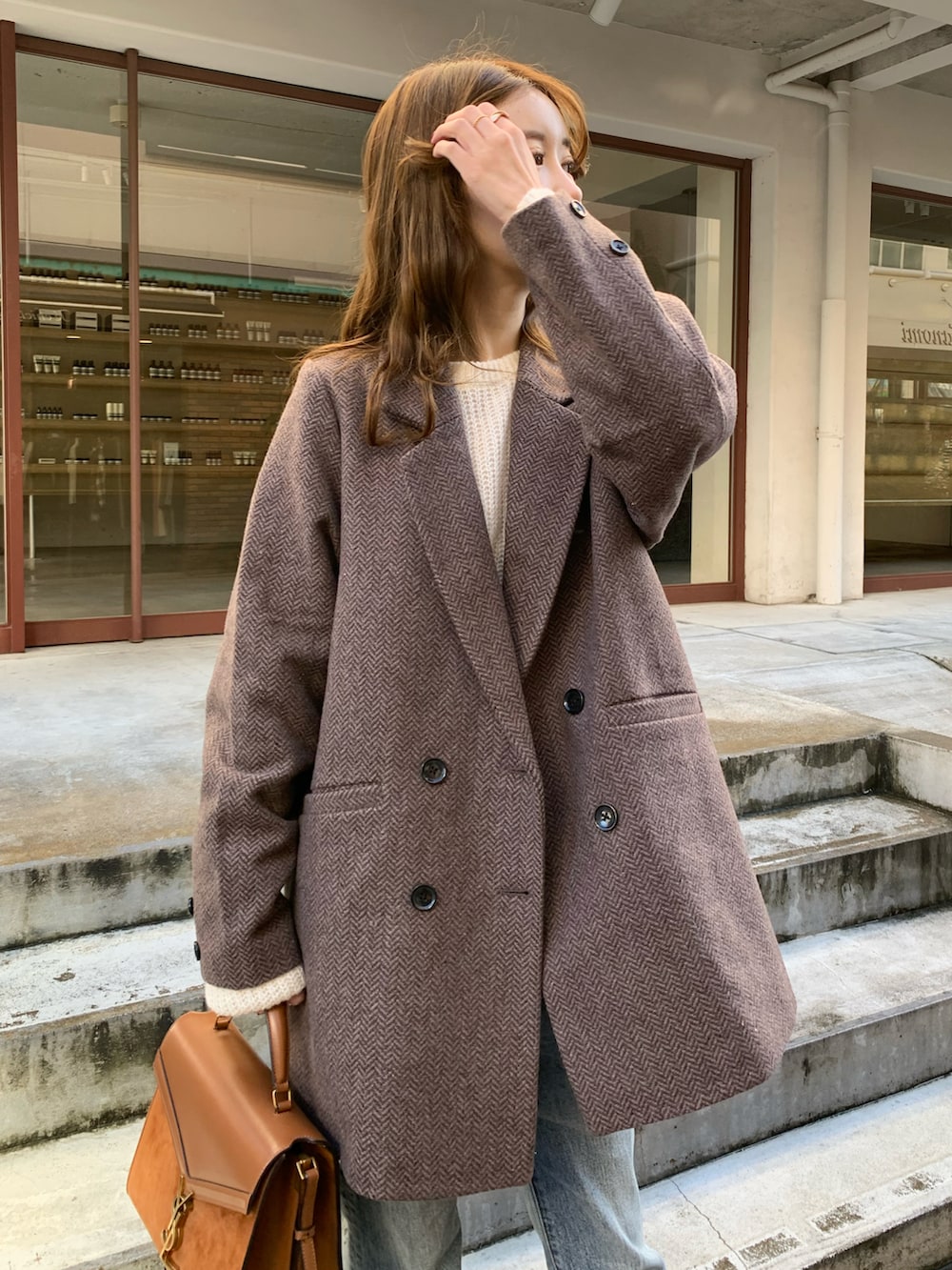 ブラウン系のジャケット/アウター、ブルー系のデニムパンツ、ブラウン系のパンプスを着用したレディースの秋コーディネートの3枚目の写真