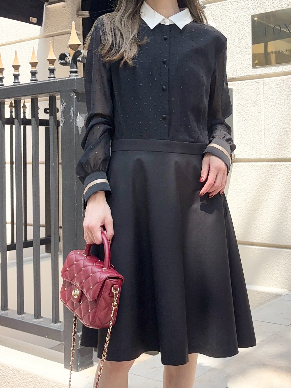 ブラック系のワンピース/ドレス、レッド系のショルダーバッグ、ブラック系のブーツを着用したレディースの夏コーディネートの3枚目の写真