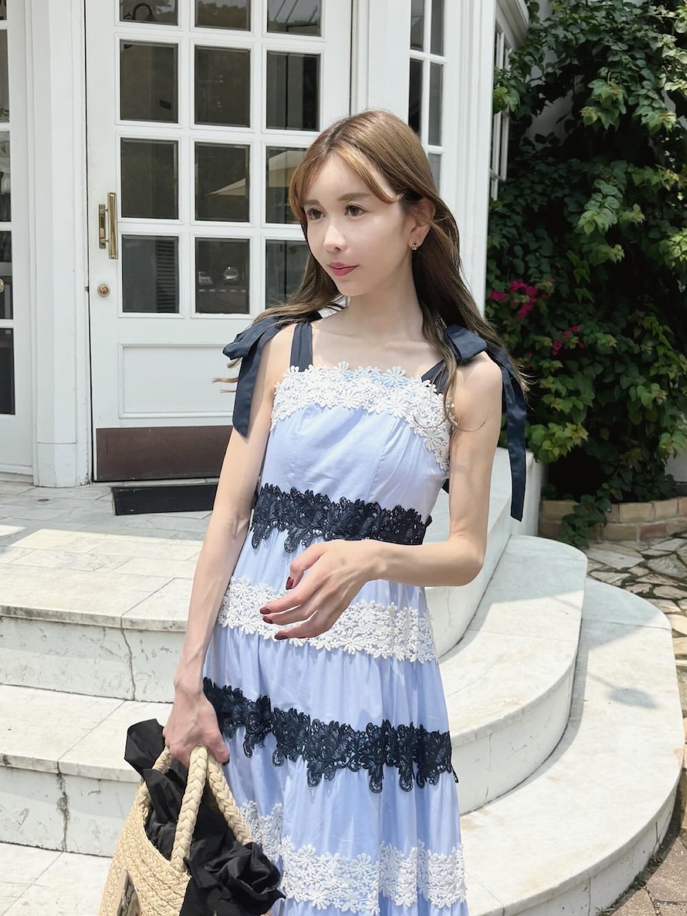 ブルー系のワンピース、ベージュ系のかごバッグ、ブラック系のサンダルを着用したレディースの夏コーディネートの2枚目の写真