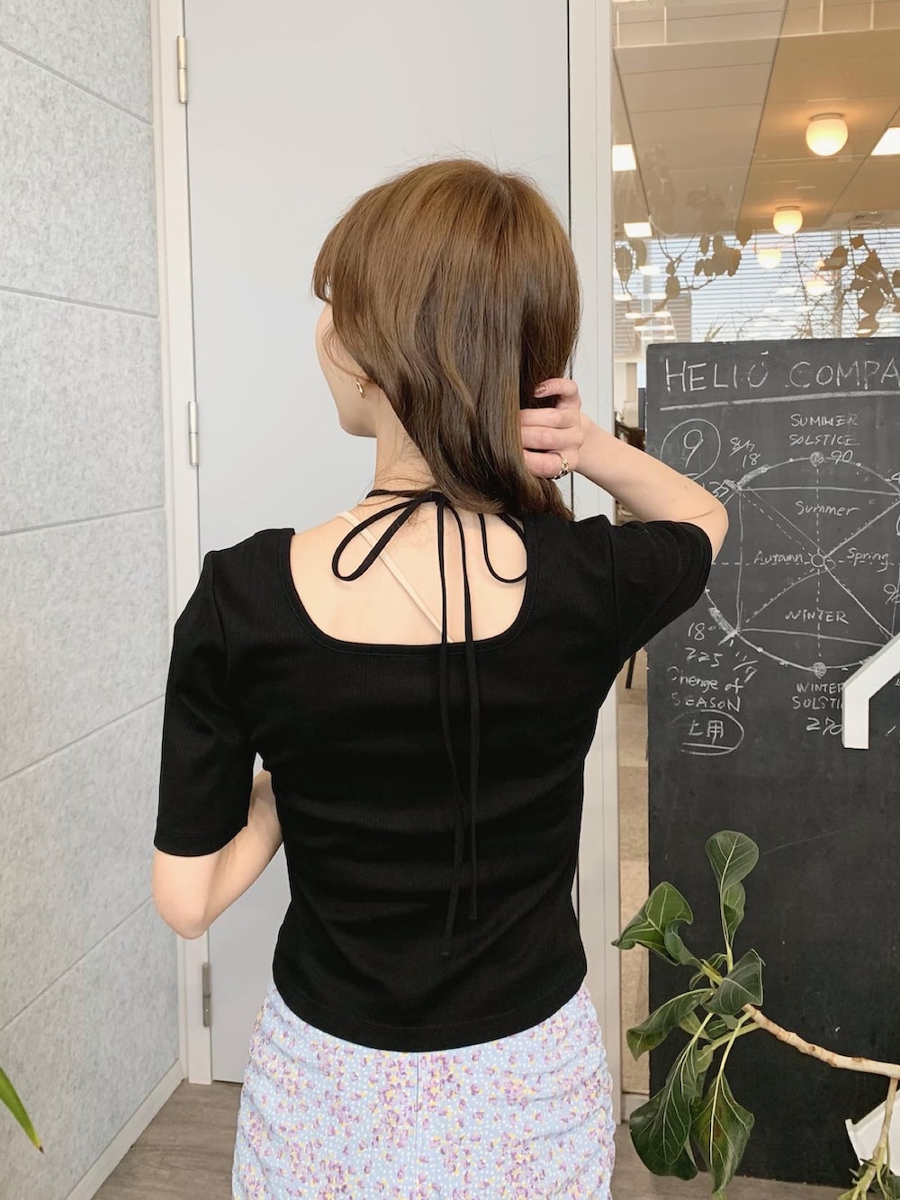 ブラック系のTシャツ/カットソー、ブルー系のスカート、ブラック系のサンダルを着用したレディースの春コーディネートの3枚目の写真