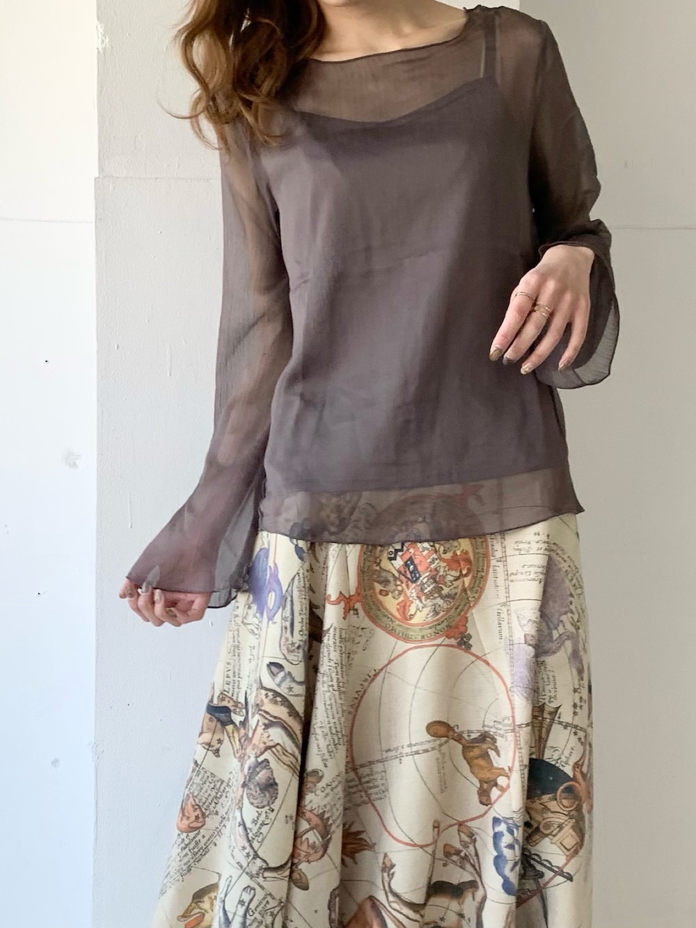 グレー系のTシャツ/カットソー、イエロー系のスカート、ブラウン系のパンプスを着用したレディースの春コーディネートの3枚目の写真