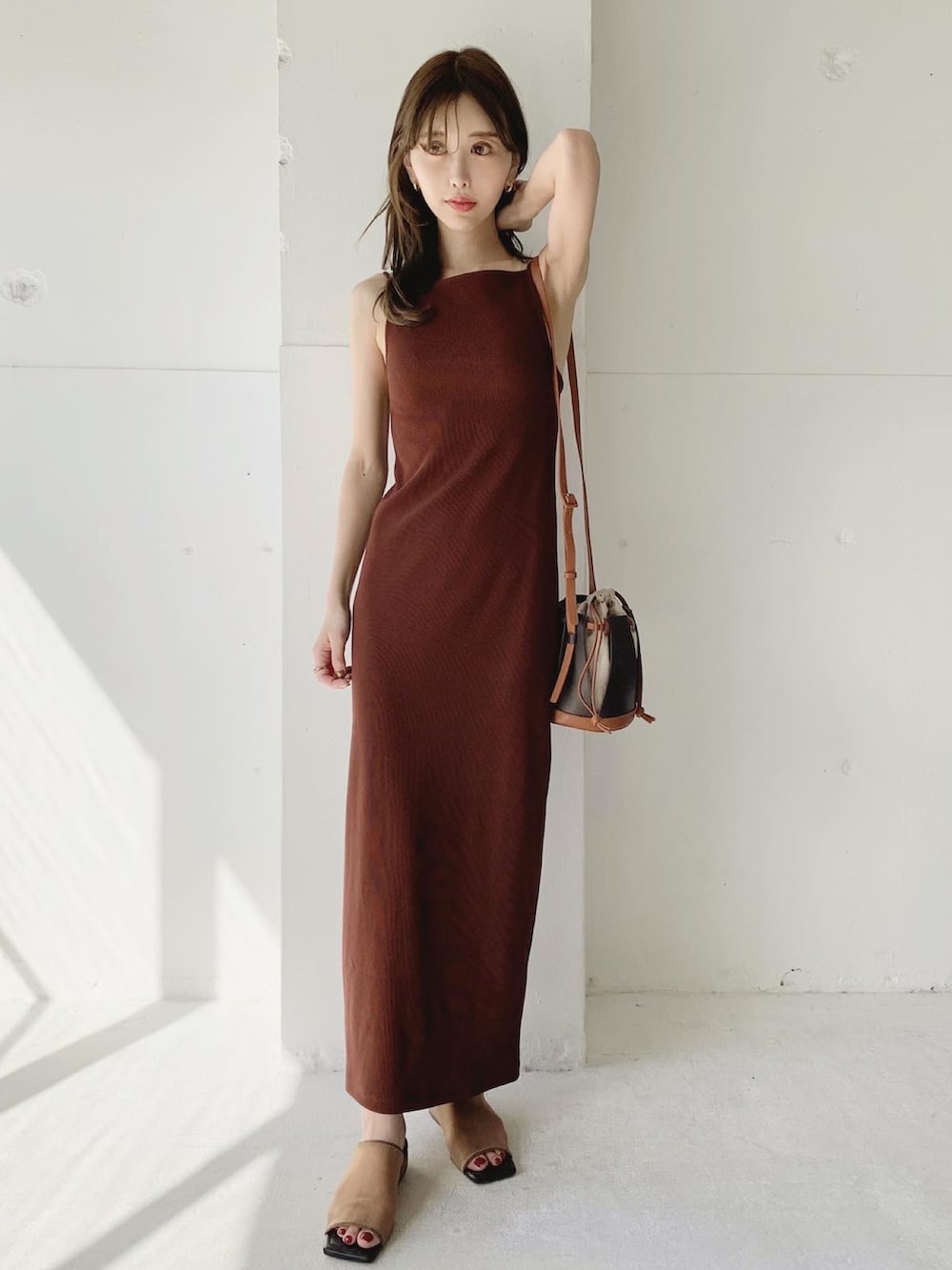 レッド系のワンピース、ブラウン系のショルダーバッグ、ブラウン系のサンダルを着用したレディースの夏コーディネートの2枚目の写真