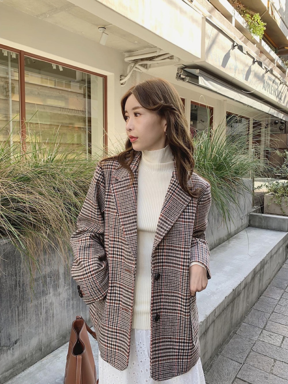 オレンジ系のテーラードジャケット、ホワイト系のニット/セーター、ホワイト系のスカートを着用したレディースの秋コーディネートの2枚目の写真