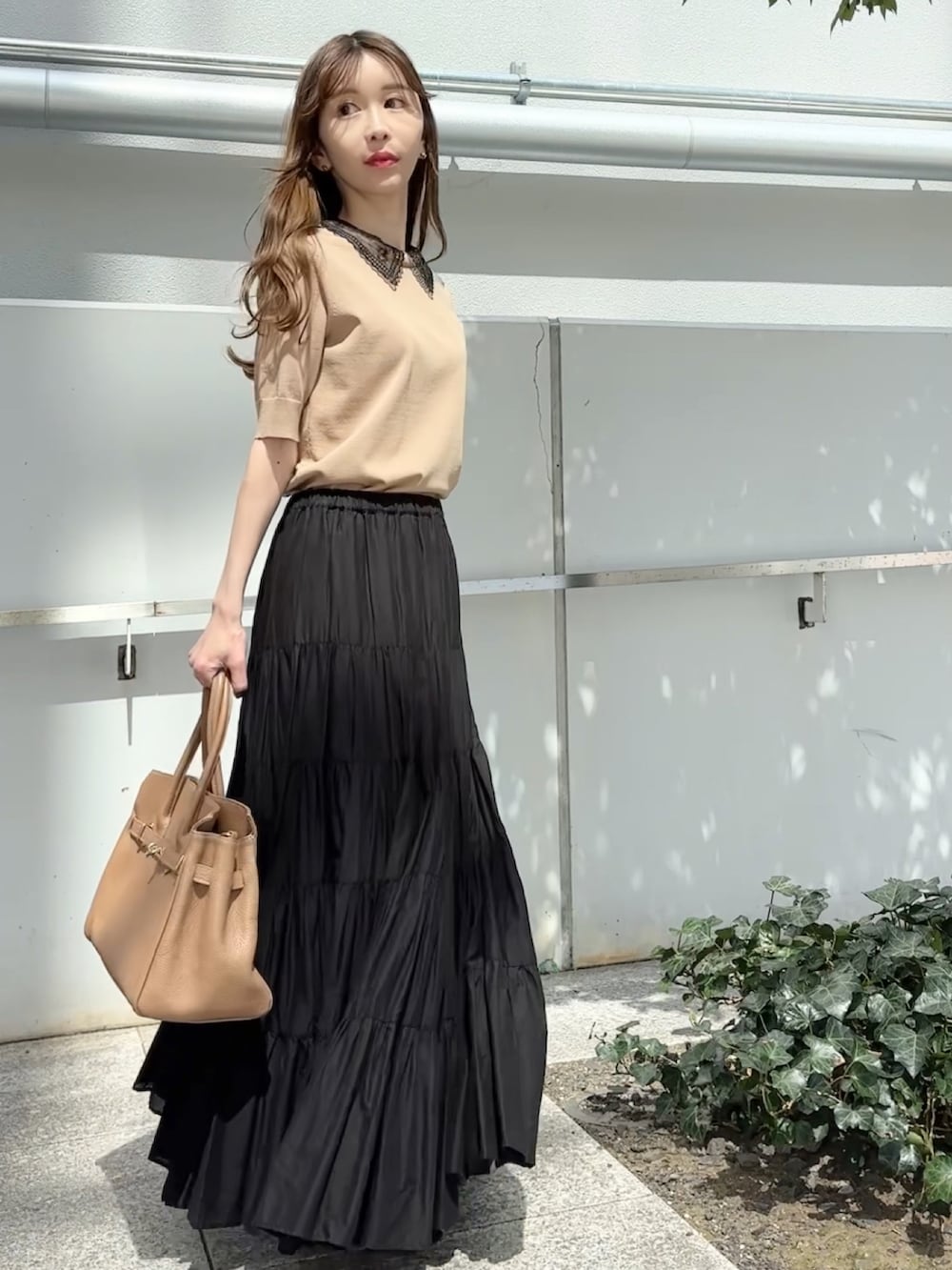 ベージュ系のニット/セーター、ブラック系のスカート、ブラック系のサンダルを着用したレディースの夏コーディネートの3枚目の写真