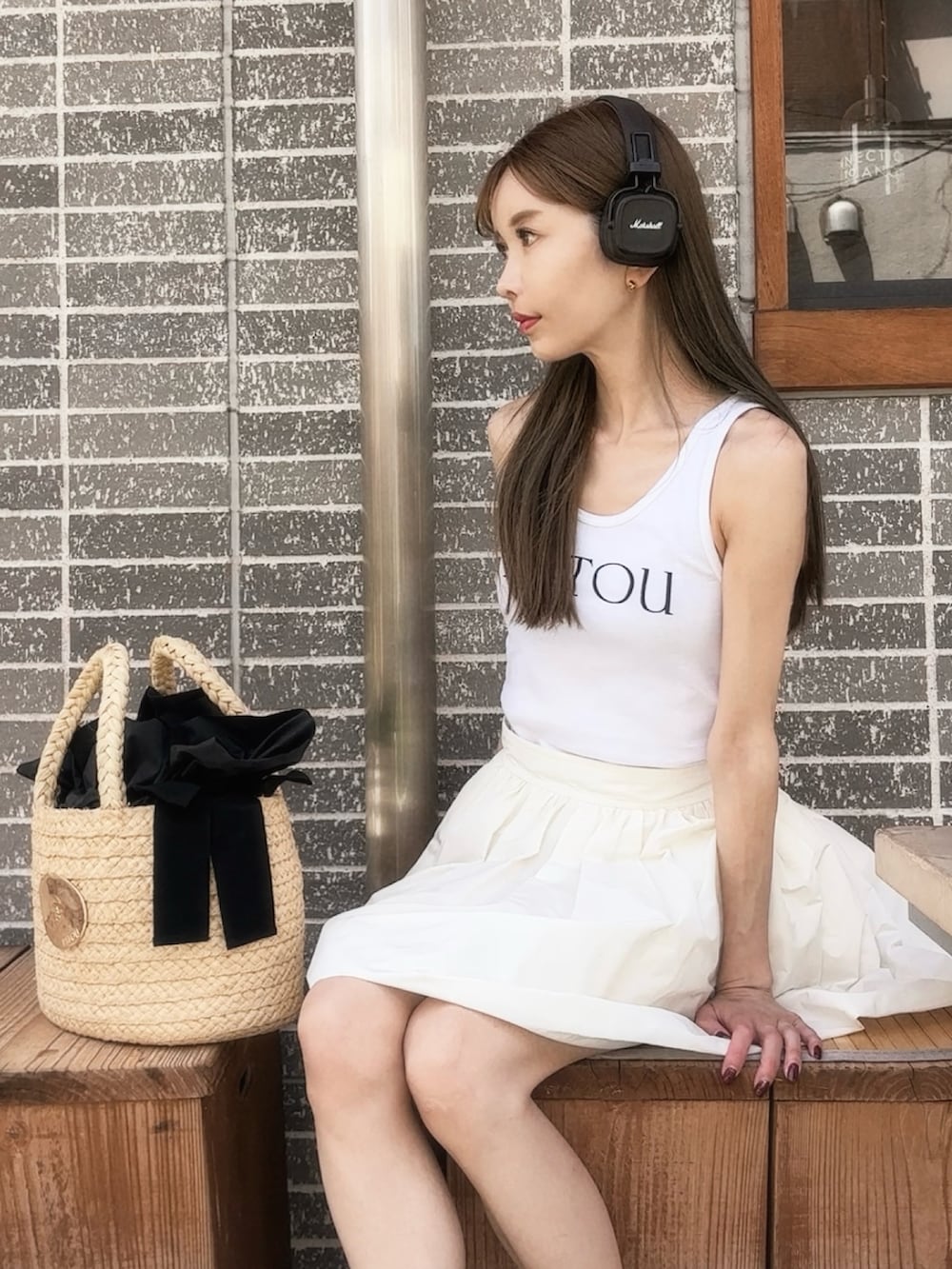 ホワイト系のトップス、ホワイト系のスカート、ベージュ系のかごバッグを着用したレディースの秋コーディネートの3枚目の写真