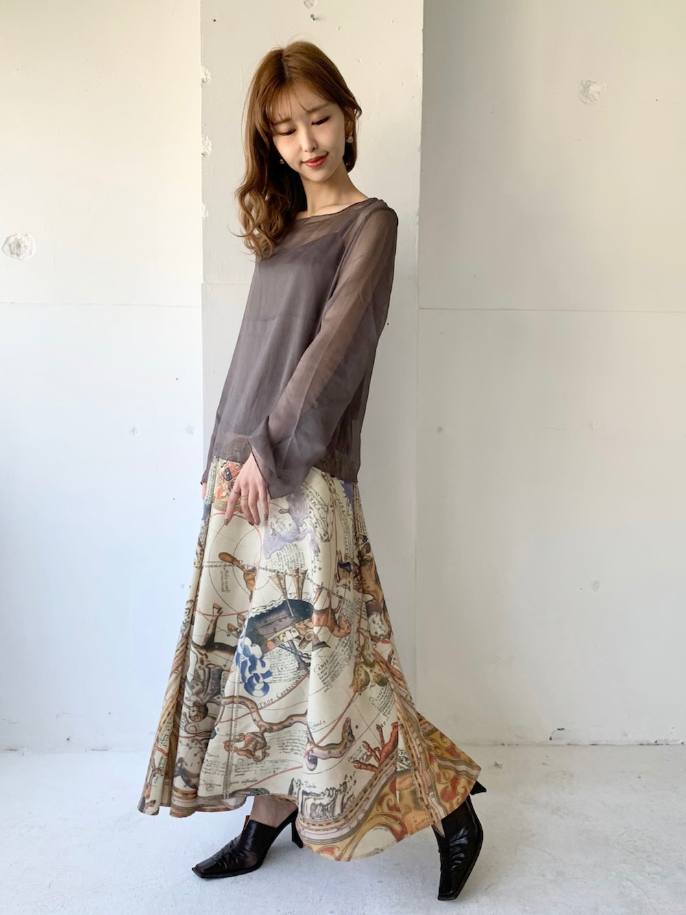 グレー系のTシャツ/カットソー、イエロー系のスカート、ブラウン系のパンプスを着用したレディースの春コーディネートの2枚目の写真