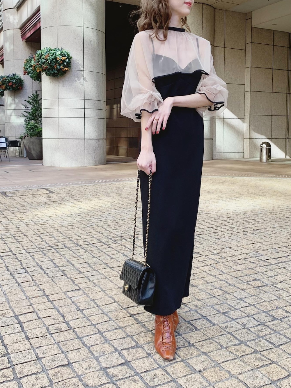 ブラック系のワンピース、ブラウン系のブーツを着用したレディースの冬コーディネートの2枚目の写真