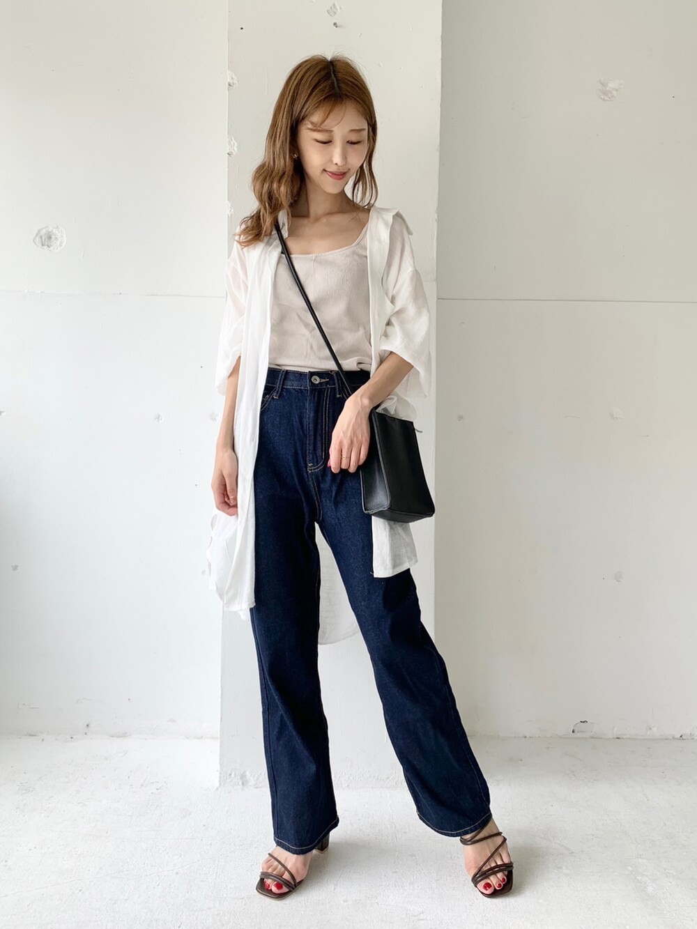 ブルー系のデニムパンツ、ホワイト系のシャツ/ブラウス、ベージュ系のタンクトップを着用したレディースの夏コーディネートの2枚目の写真