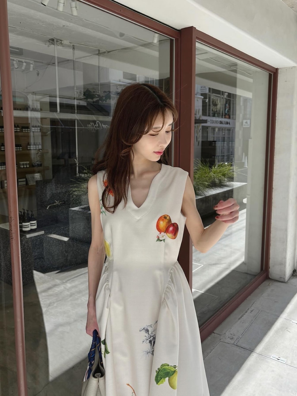 ホワイト系のワンピース、ブラウン系のブーツを着用したレディースの春コーディネートの3枚目の写真