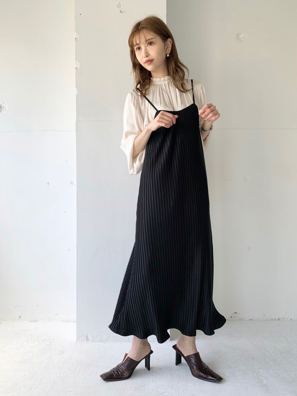 ブラック系のワンピース、ホワイト系のシャツ/ブラウスを着用したレディースの春コーディネートの2枚目の写真