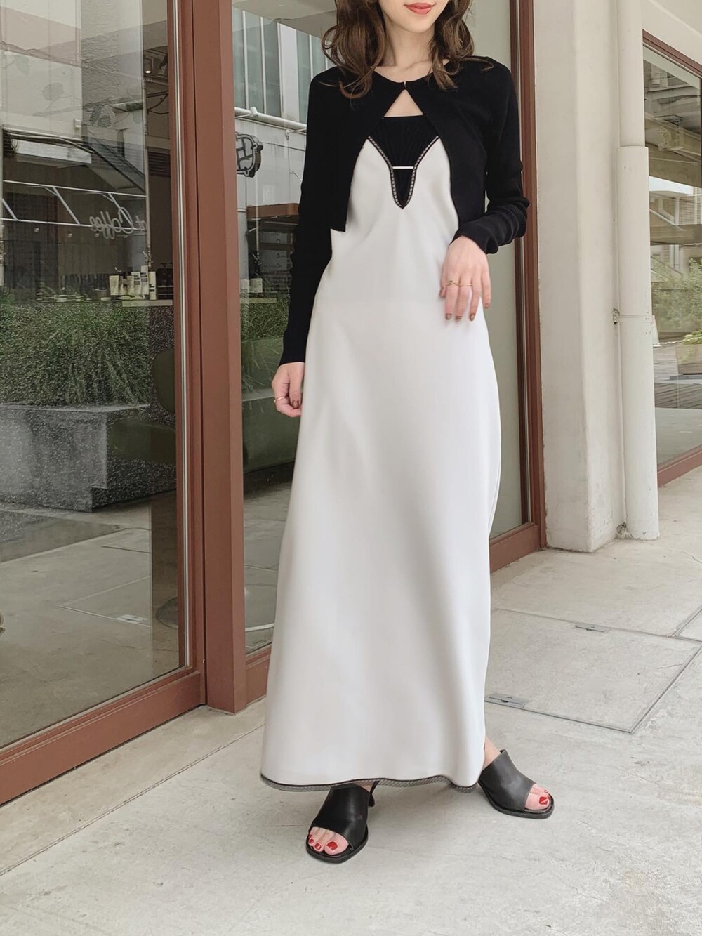 グレー系のワンピース、ブラック系のチューブトップ、ブラック系のカーディガン/ボレロを着用したレディースの春コーディネートの3枚目の写真