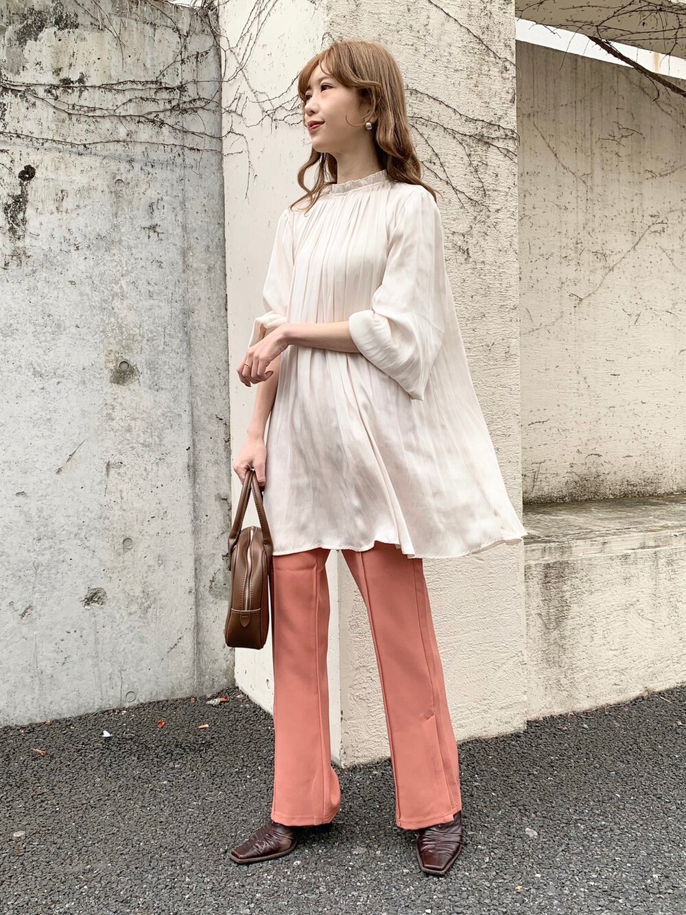 ホワイト系のシャツ/ブラウス、ピンク系のスラックス、ブラウン系のパンプスを着用したレディースの冬コーディネートの2枚目の写真
