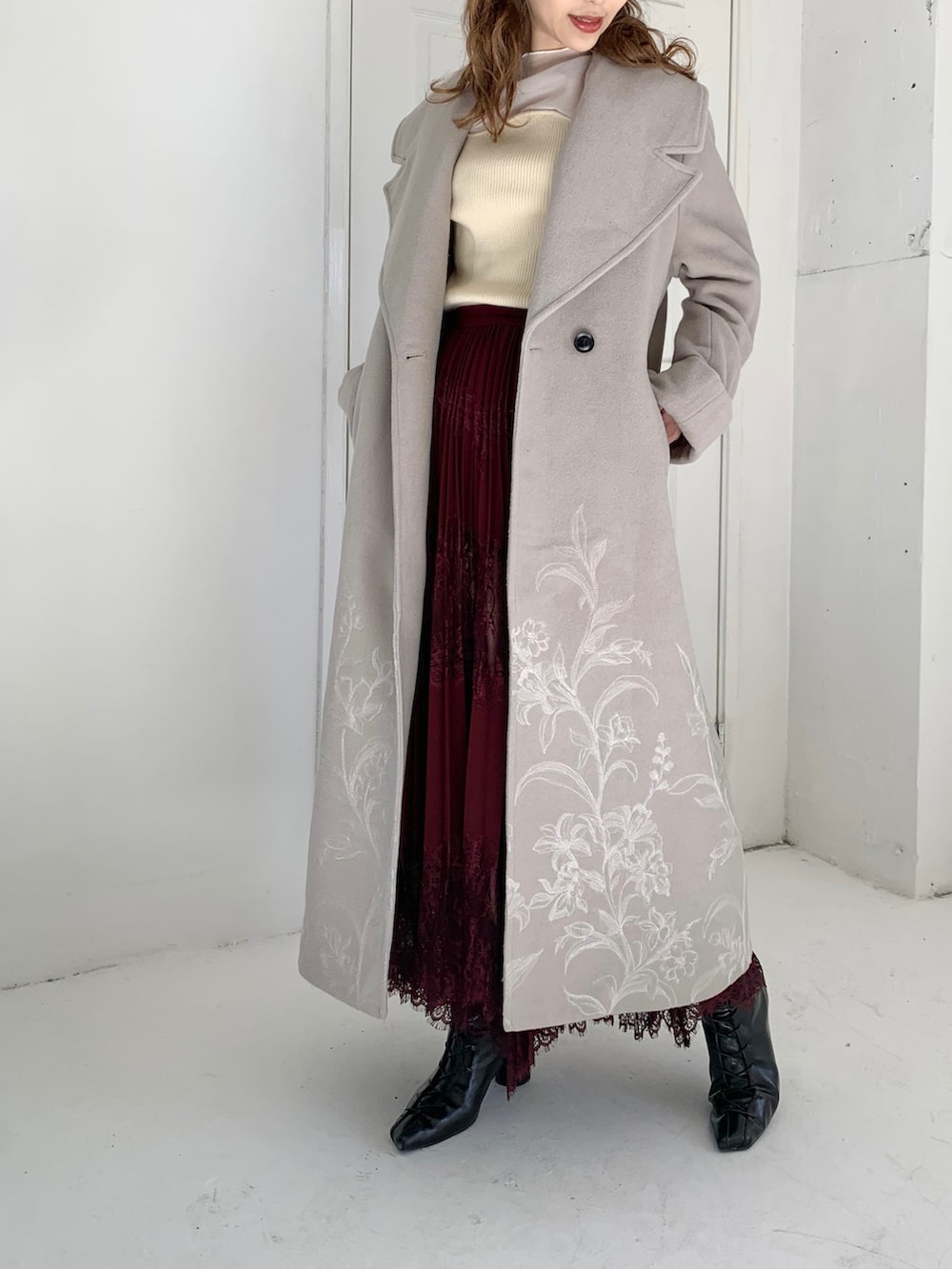 ホワイト系のニット/セーター、レッド系のスカート、ベージュ系のジャケット/アウターを着用したレディースの冬コーディネートの2枚目の写真