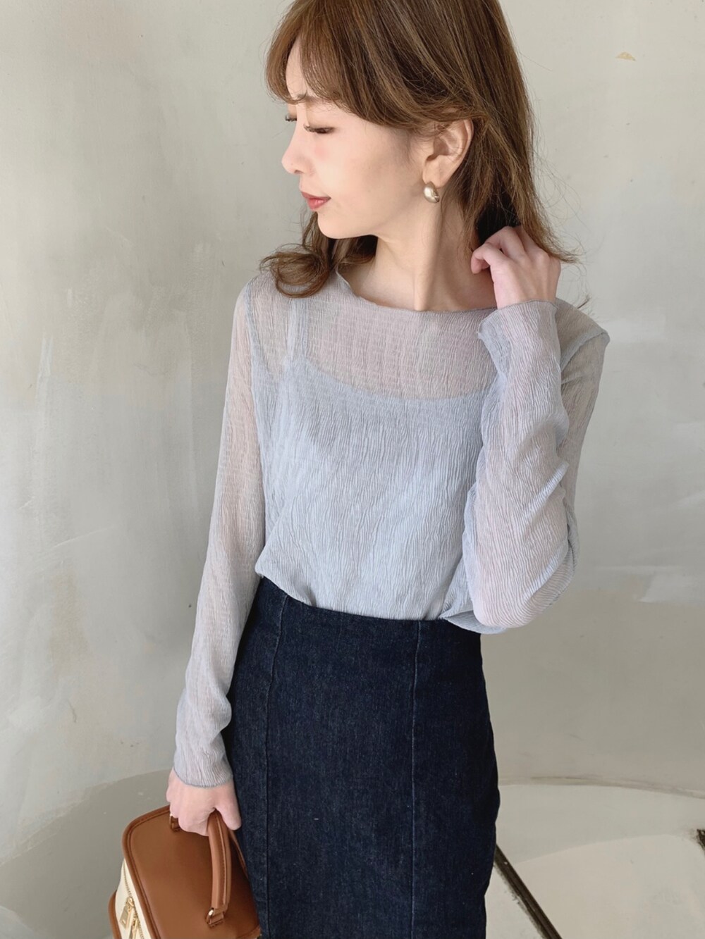 グリーン系のTシャツ/カットソー、ブラウン系のショルダーバッグ、ブラウン系のブーツを着用したレディースの冬コーディネートの2枚目の写真