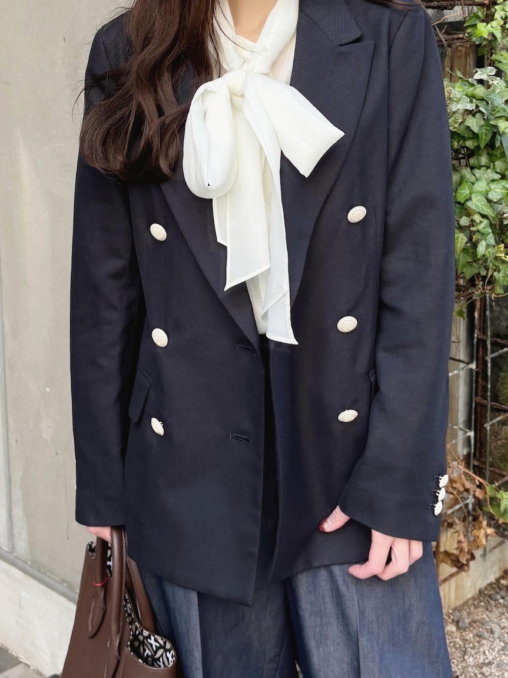 ブルー系のテーラードジャケット、ブラウン系のトートバッグ、ホワイト系のシャツ/ブラウスを着用したレディースの春コーディネートの4枚目の写真