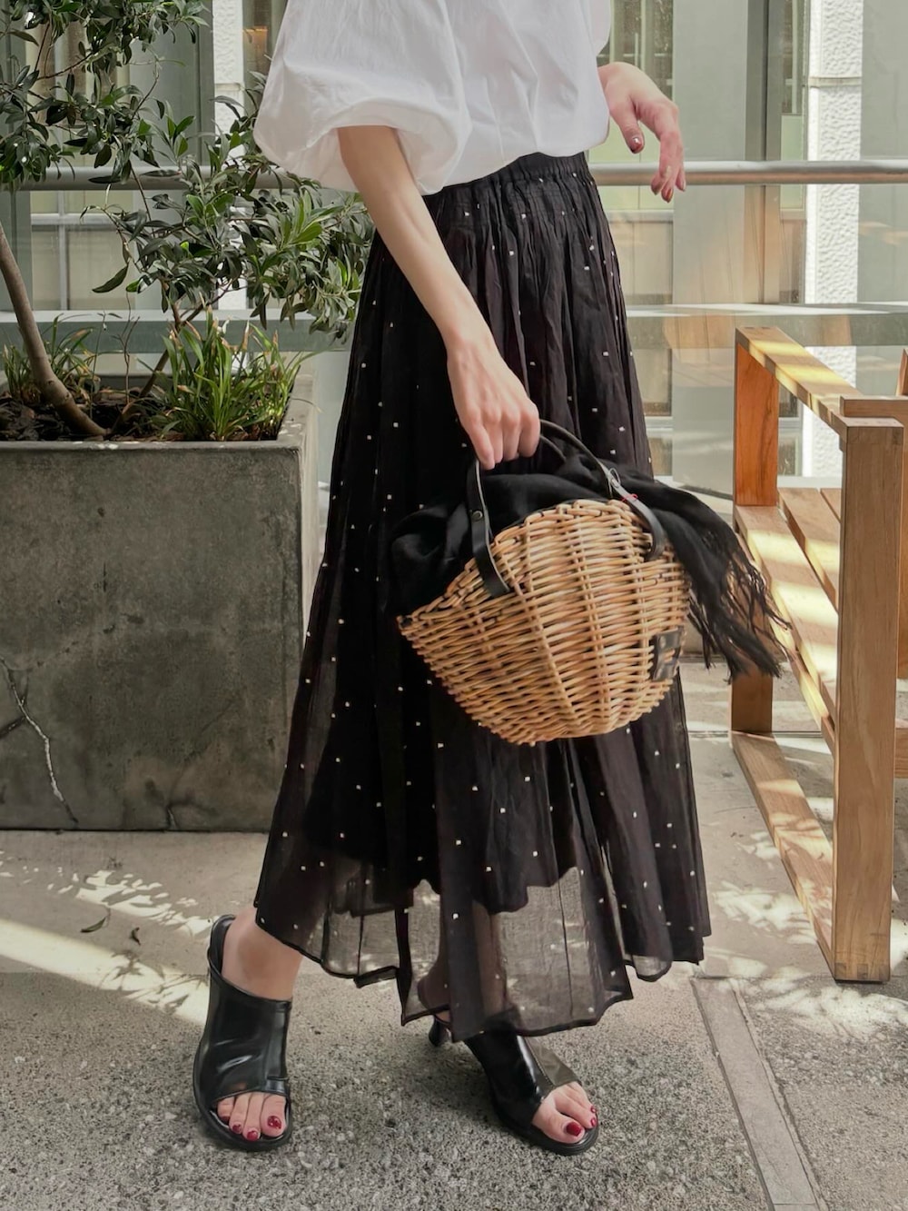 ホワイト系のシャツ/ブラウス、ブラック系のスカート、ベージュ系のバッグを着用したレディースの夏コーディネートの2枚目の写真