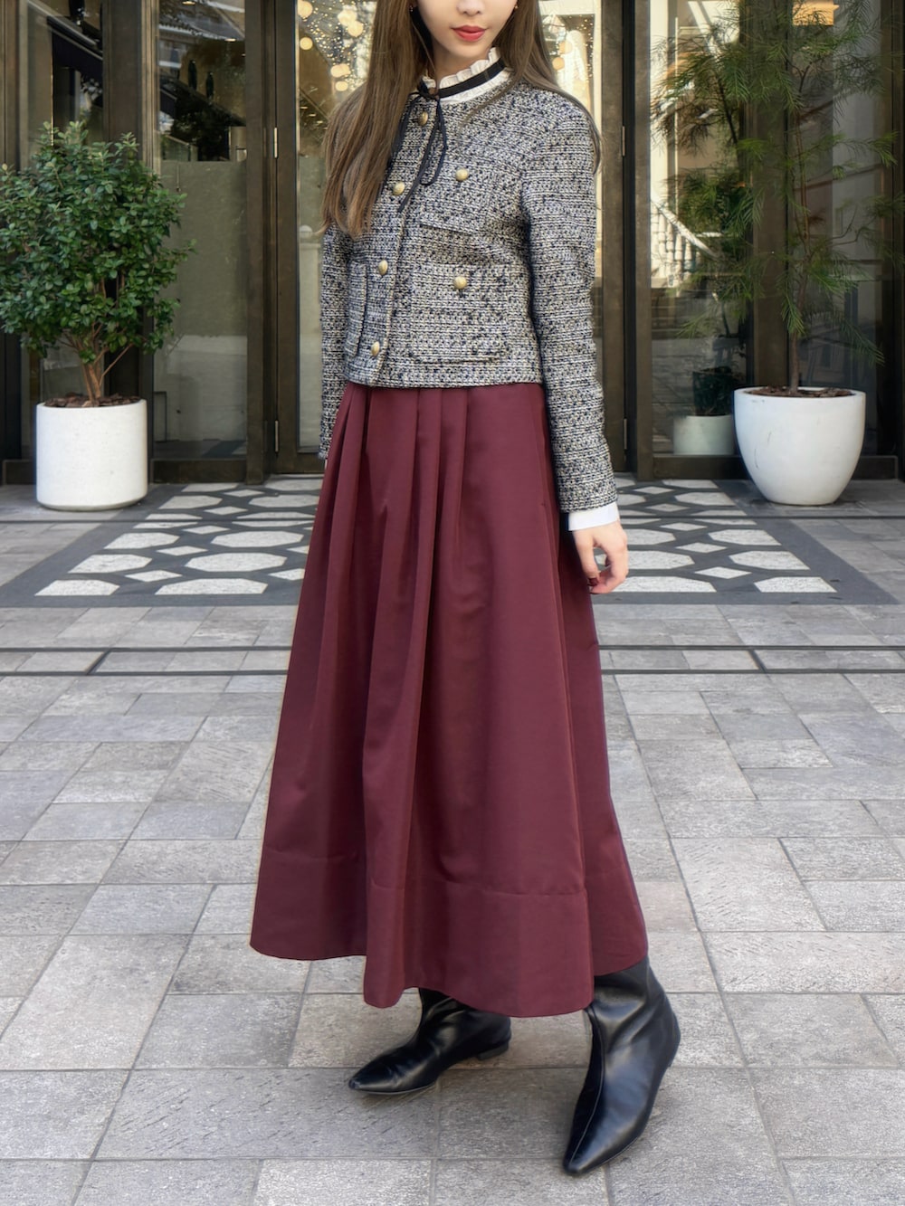 グレー系のノーカラージャケット、レッド系のスカート、ホワイト系のシャツ/ブラウスを着用したレディースの秋コーディネートの3枚目の写真