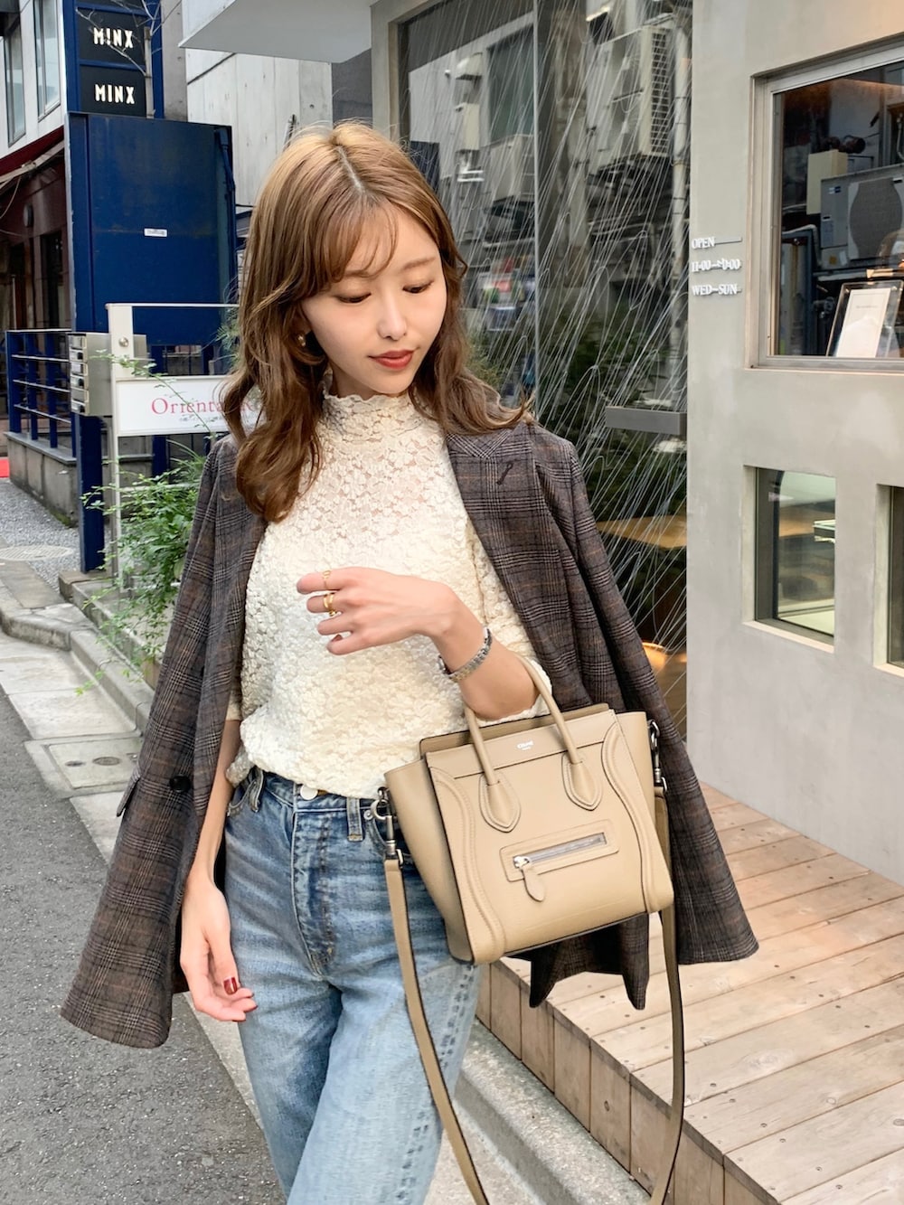 ブルー系のデニムパンツ、ホワイト系のTシャツ/カットソー、ブラウン系のパンプスを着用したレディースの秋コーディネートの2枚目の写真