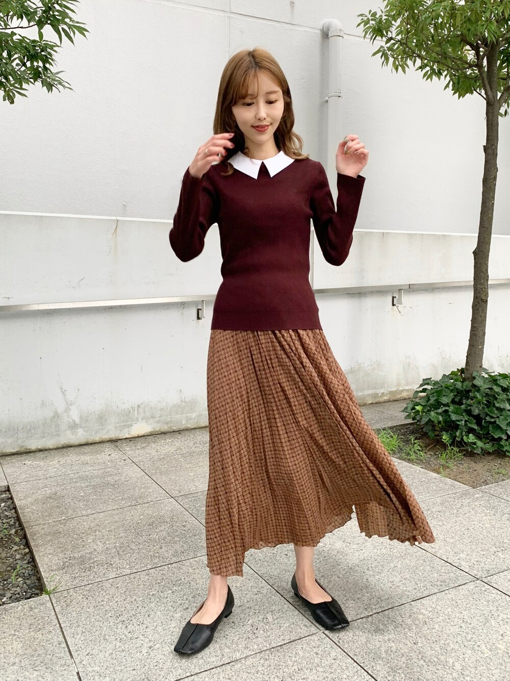 レッド系のニット/セーター、ブラウン系のスカート、ブラック系のその他シューズを着用したレディースの秋コーディネートの2枚目の写真