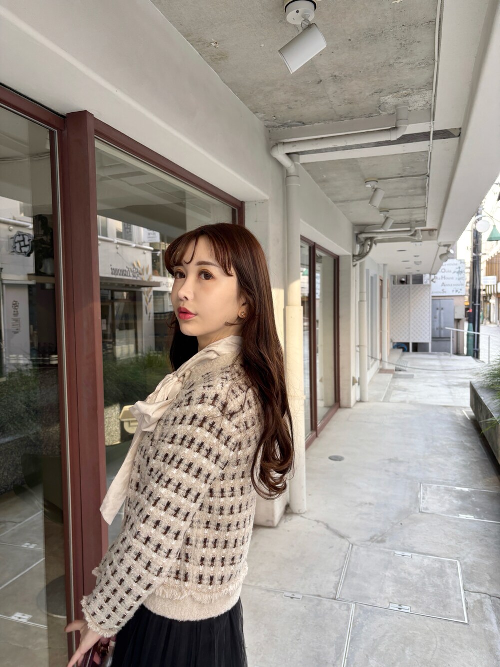 ベージュ系のカーディガン/ボレロ、ホワイト系のシャツ/ブラウス、ブラック系のスカートを着用したレディースの冬コーディネートの2枚目の写真