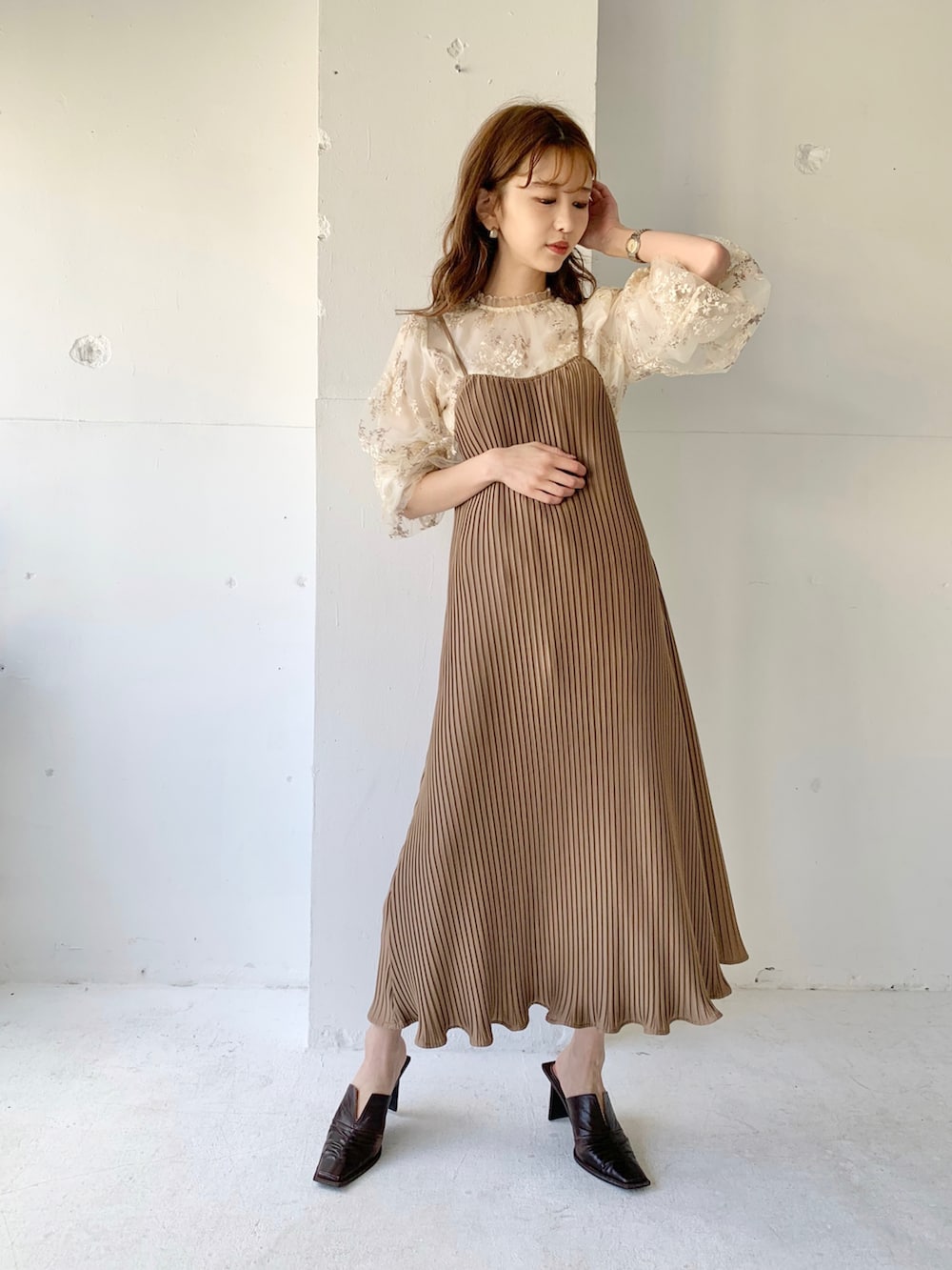 ベージュ系のワンピース、ホワイト系のシャツ/ブラウス、ブラウン系のパンプスを着用したレディースの春コーディネートの2枚目の写真