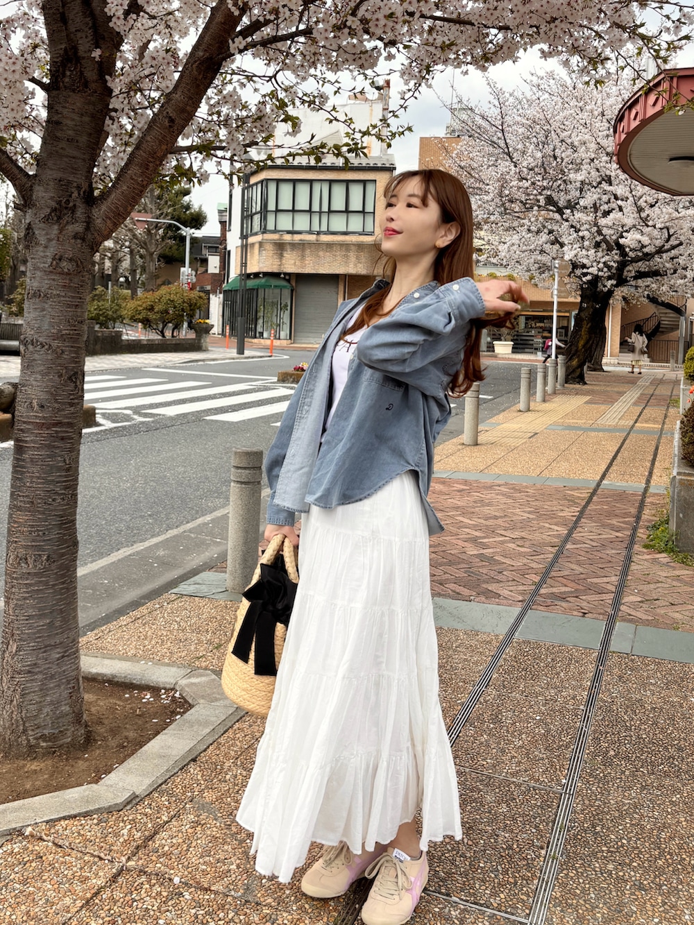 ブルー系のシャツ/ブラウス、ホワイト系のスカート、ベージュ系のスニーカーを着用したレディースの春コーディネートの3枚目の写真