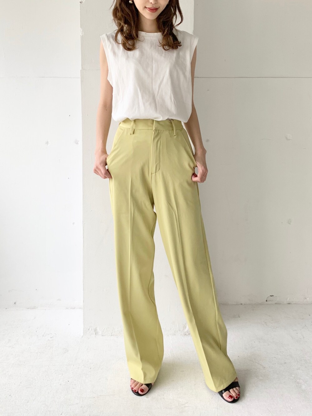イエロー系のその他パンツ、ホワイト系のTシャツ/カットソー、ブラック系のサンダルを着用したレディースの夏コーディネートの2枚目の写真