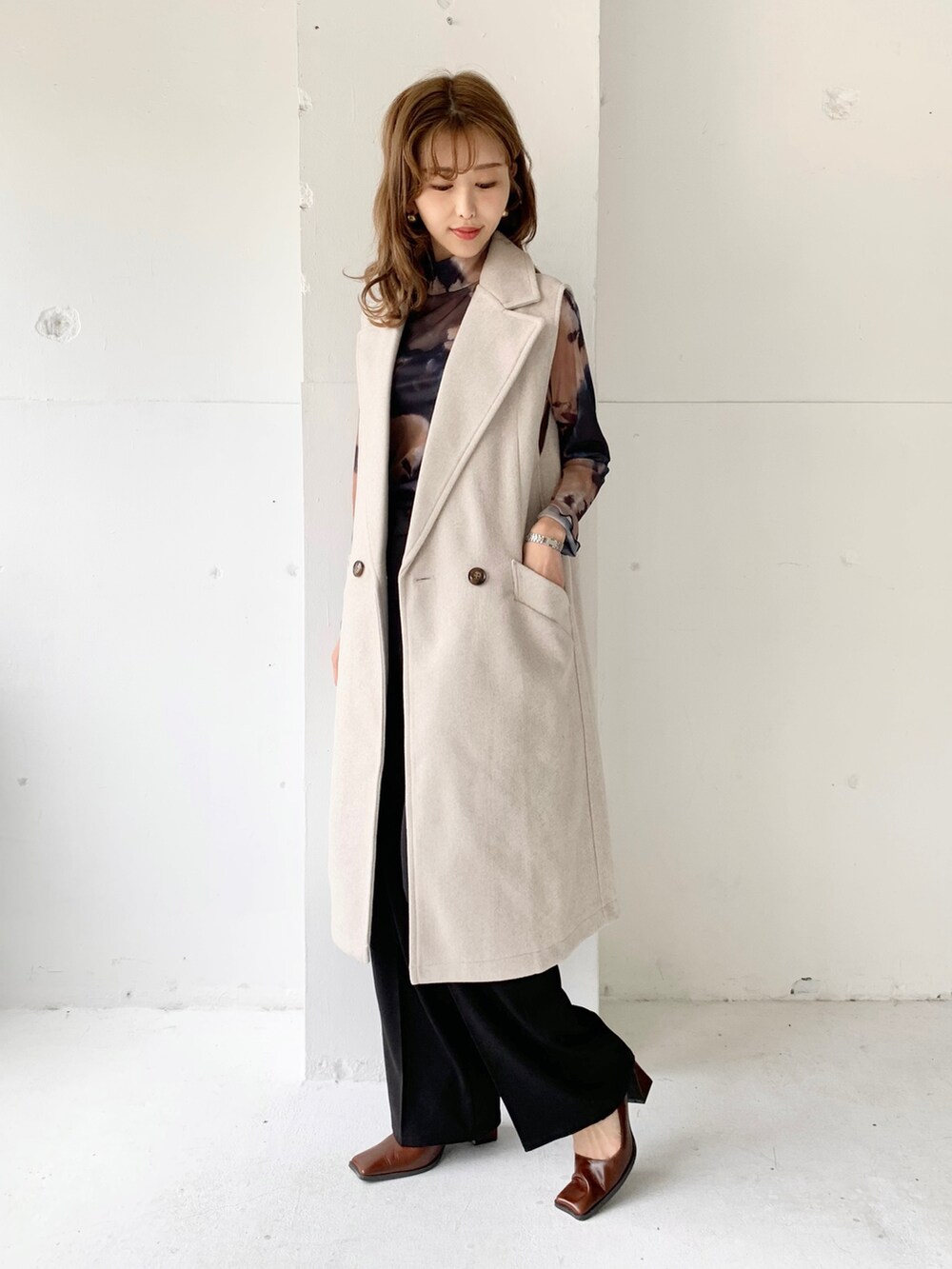 ベージュ系のベスト、ブラック系のトップス、ブラック系のその他パンツを着用したレディースの秋コーディネートの2枚目の写真