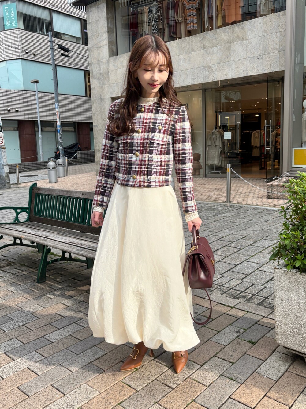 ブラウン系のノーカラージャケット、ホワイト系のスカート、ホワイト系のTシャツ/カットソーを着用したレディースの春コーディネートの2枚目の写真