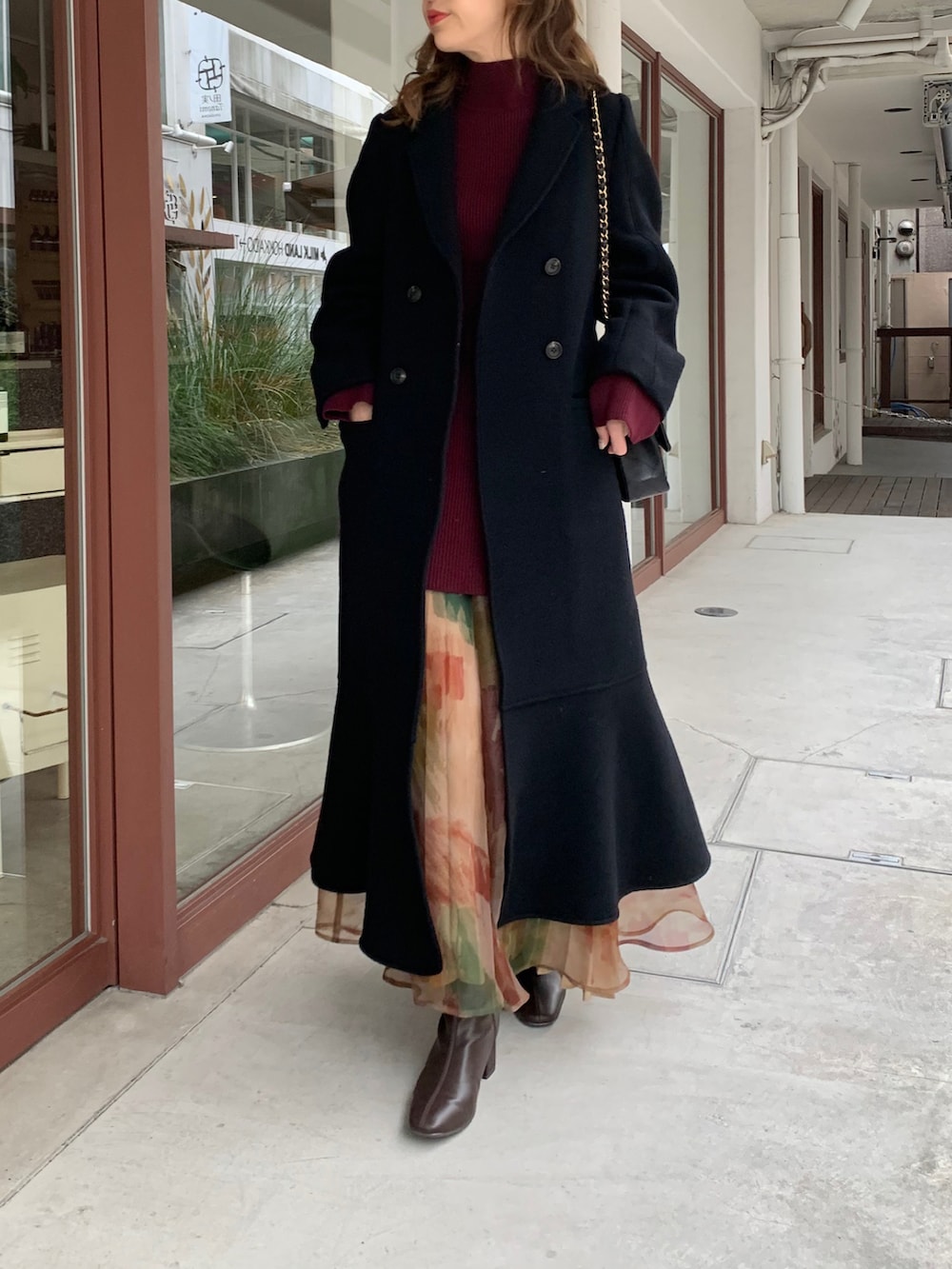 ブラック系のその他アウター、レッド系のニット/セーター、その他のスカートを着用したレディースの秋コーディネートの2枚目の写真