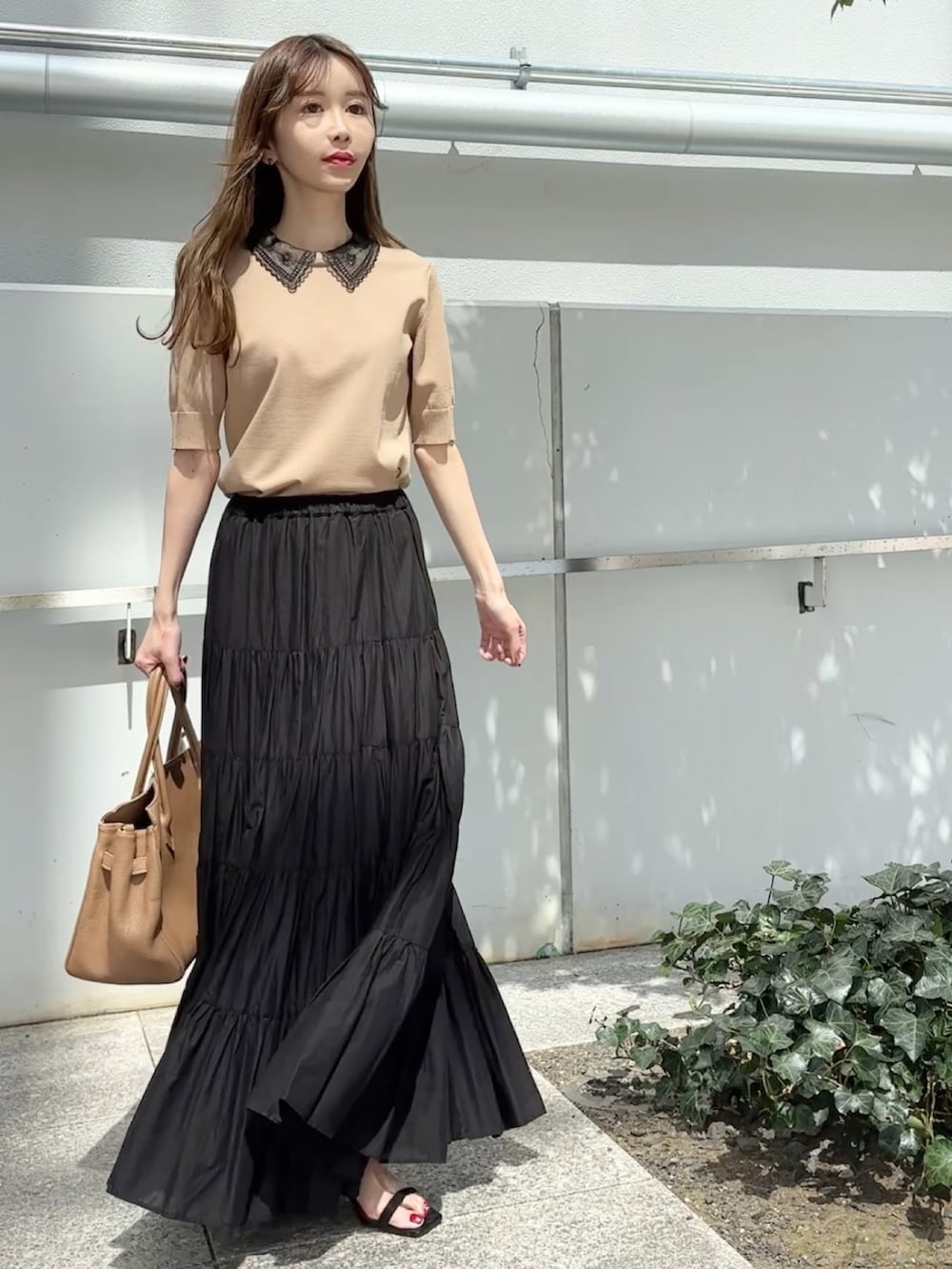 ベージュ系のニット/セーター、ブラック系のスカート、ブラック系のサンダルを着用したレディースの夏コーディネートの2枚目の写真