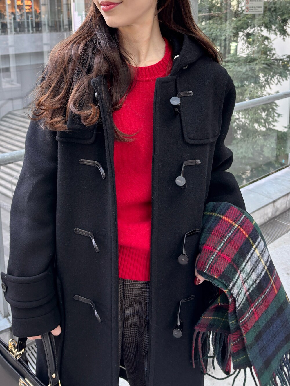 ブラック系のダッフルコート、レッド系のニット/セーター、ブラウン系のその他パンツを着用したレディースの冬コーディネートの4枚目の写真