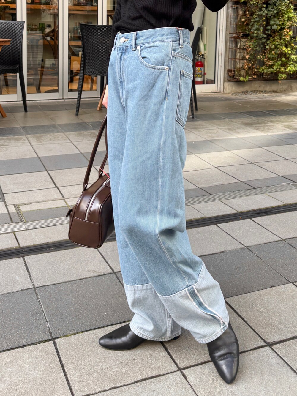 ブルー系のデニムパンツ、ブラック系のブーツ、ブラック系のニット/セーターを着用したレディースの冬コーディネートの4枚目の写真