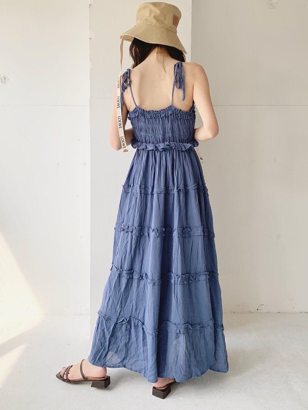 ブルー系のワンピース/ドレス、ブラウン系のサンダル、ベージュ系の帽子を着用したレディースの夏コーディネートの4枚目の写真