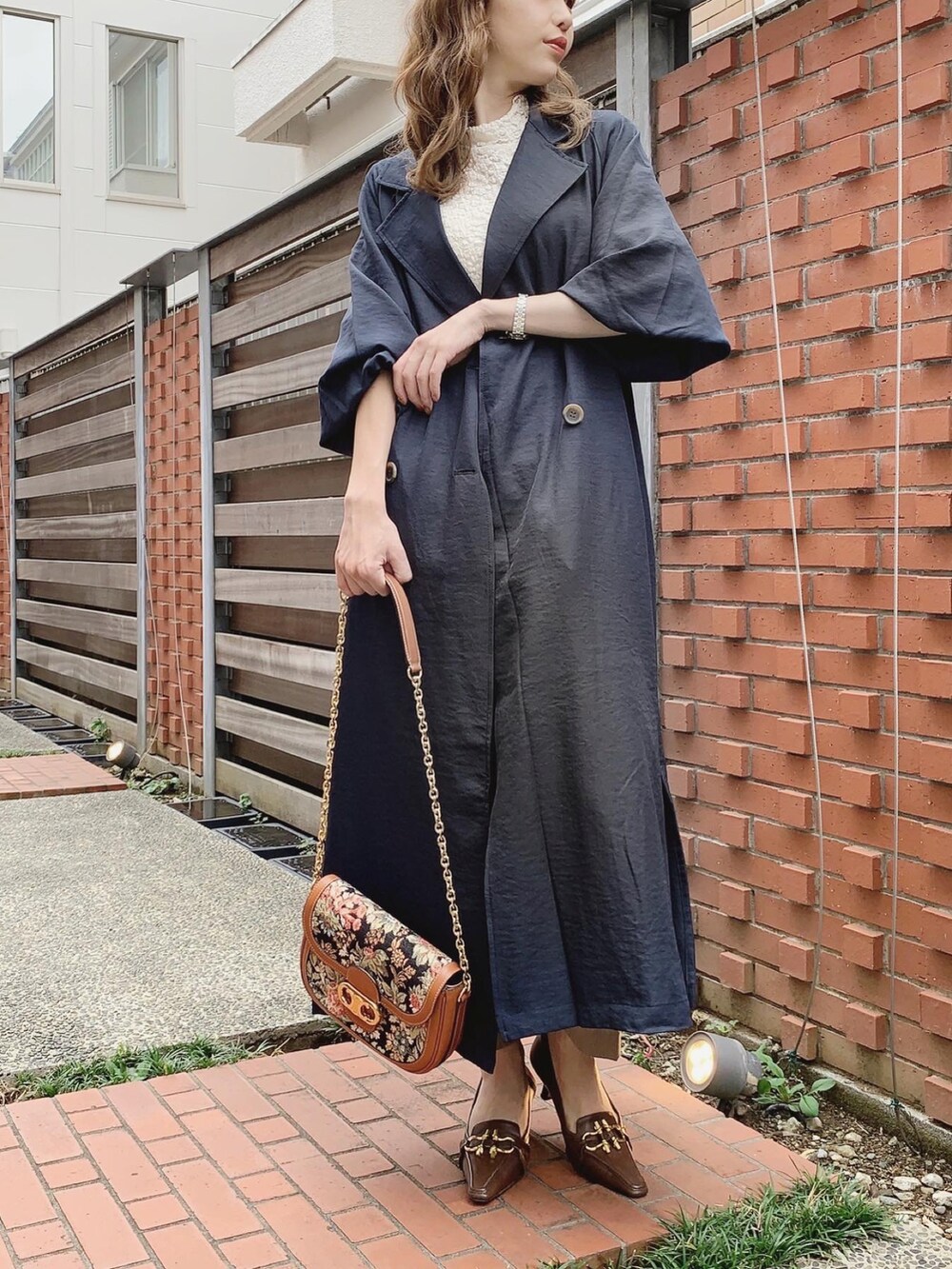 ブルー系のトレンチコート、ホワイト系のTシャツ/カットソー、ベージュ系のその他パンツを着用したレディースの秋コーディネートの3枚目の写真