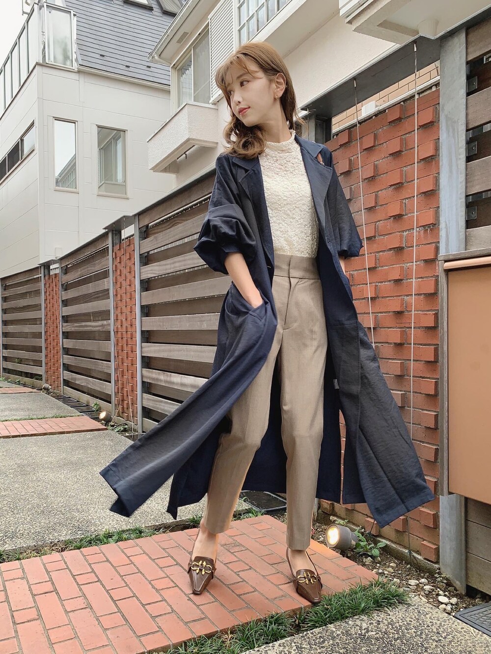 ブルー系のトレンチコート、ホワイト系のTシャツ/カットソー、ベージュ系のその他パンツを着用したレディースの秋コーディネートの2枚目の写真