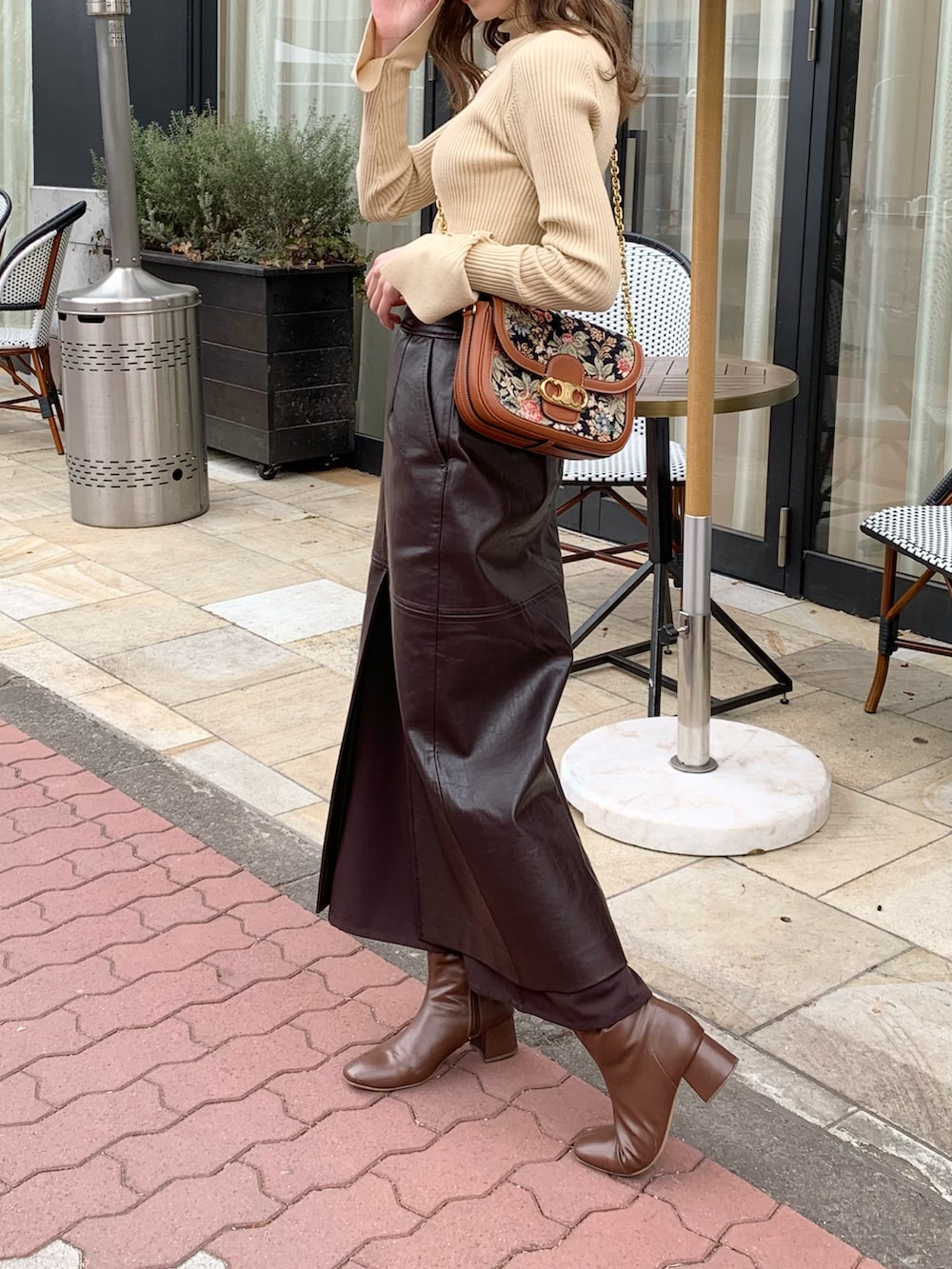 ベージュ系のニット/セーター、ブラウン系のバッグ、ブラウン系のスカートを着用したレディースの冬コーディネートの2枚目の写真