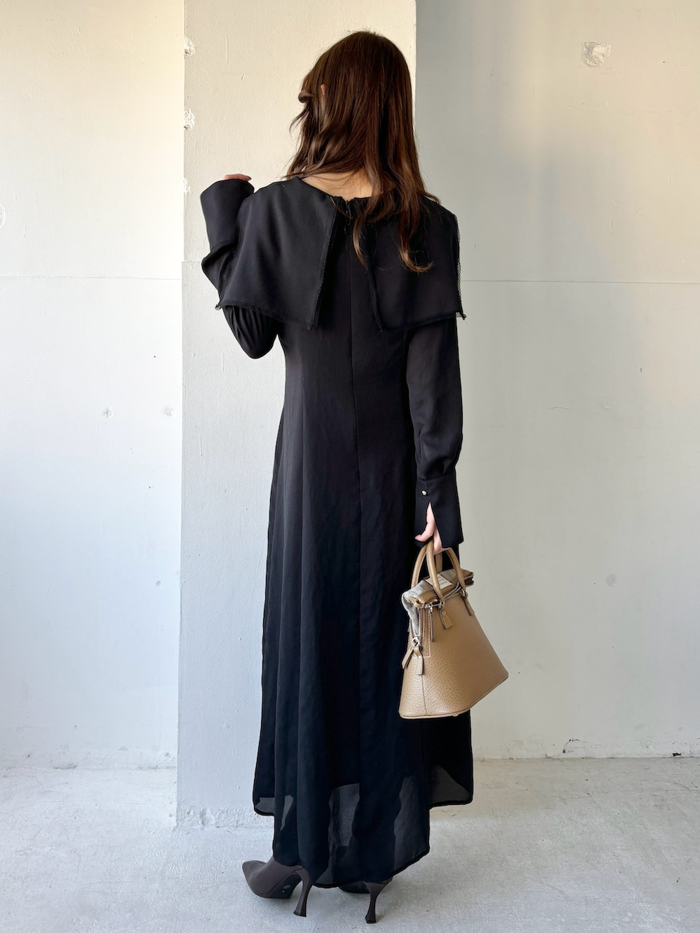 ブラック系のワンピース、ブラウン系のブーツを着用したレディースの冬コーディネートの3枚目の写真