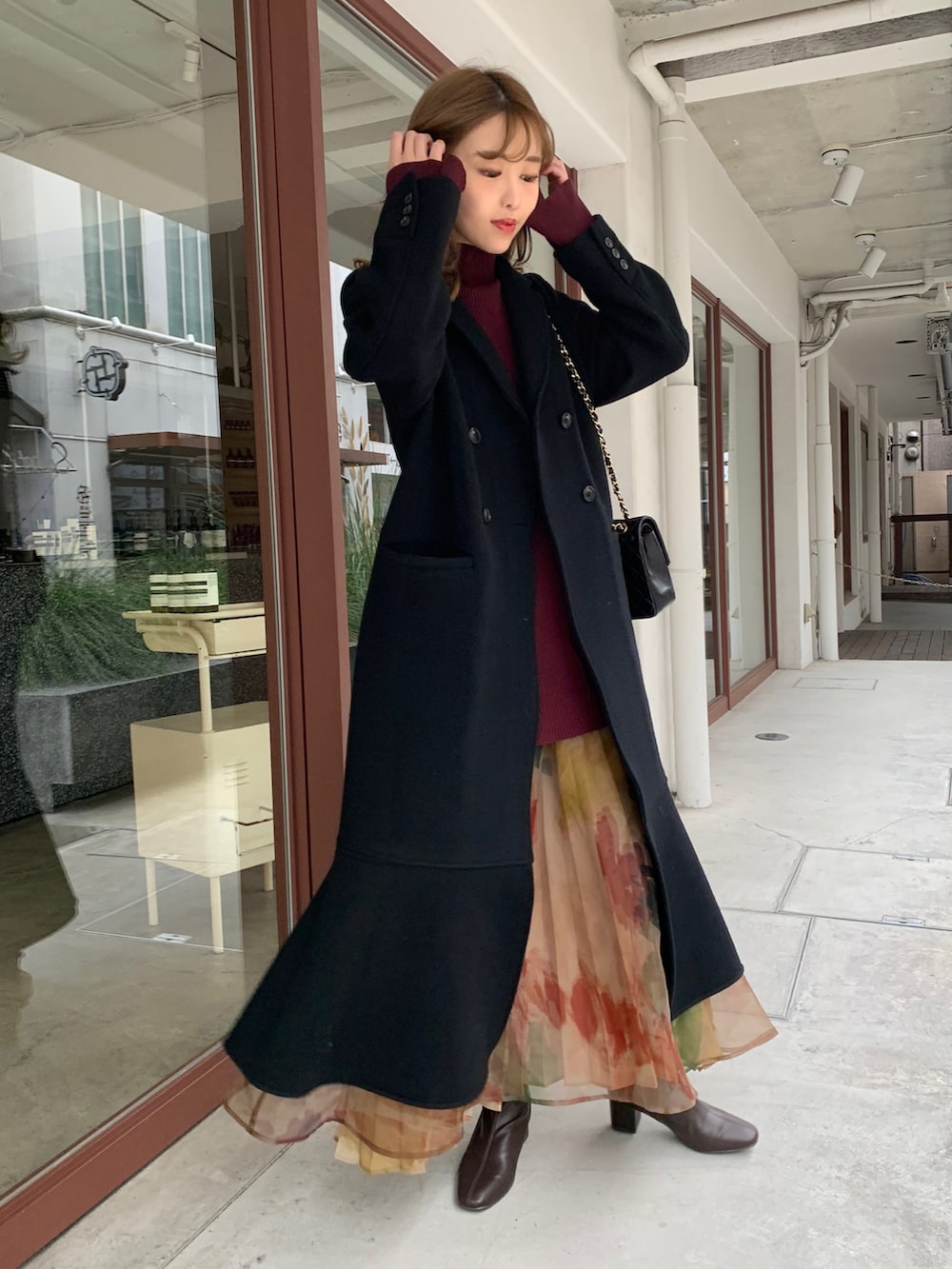 ブラック系のその他アウター、レッド系のニット/セーター、その他のスカートを着用したレディースの秋コーディネートの3枚目の写真