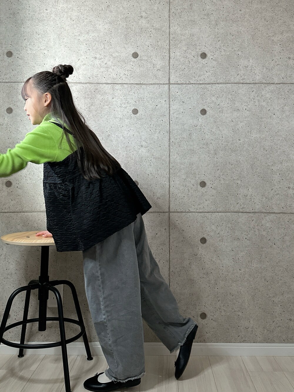 ブラック系のキャミソール、ブラック系のバレエシューズ、グレー系のデニムパンツを着用したキッズの冬コーディネートの5枚目の写真