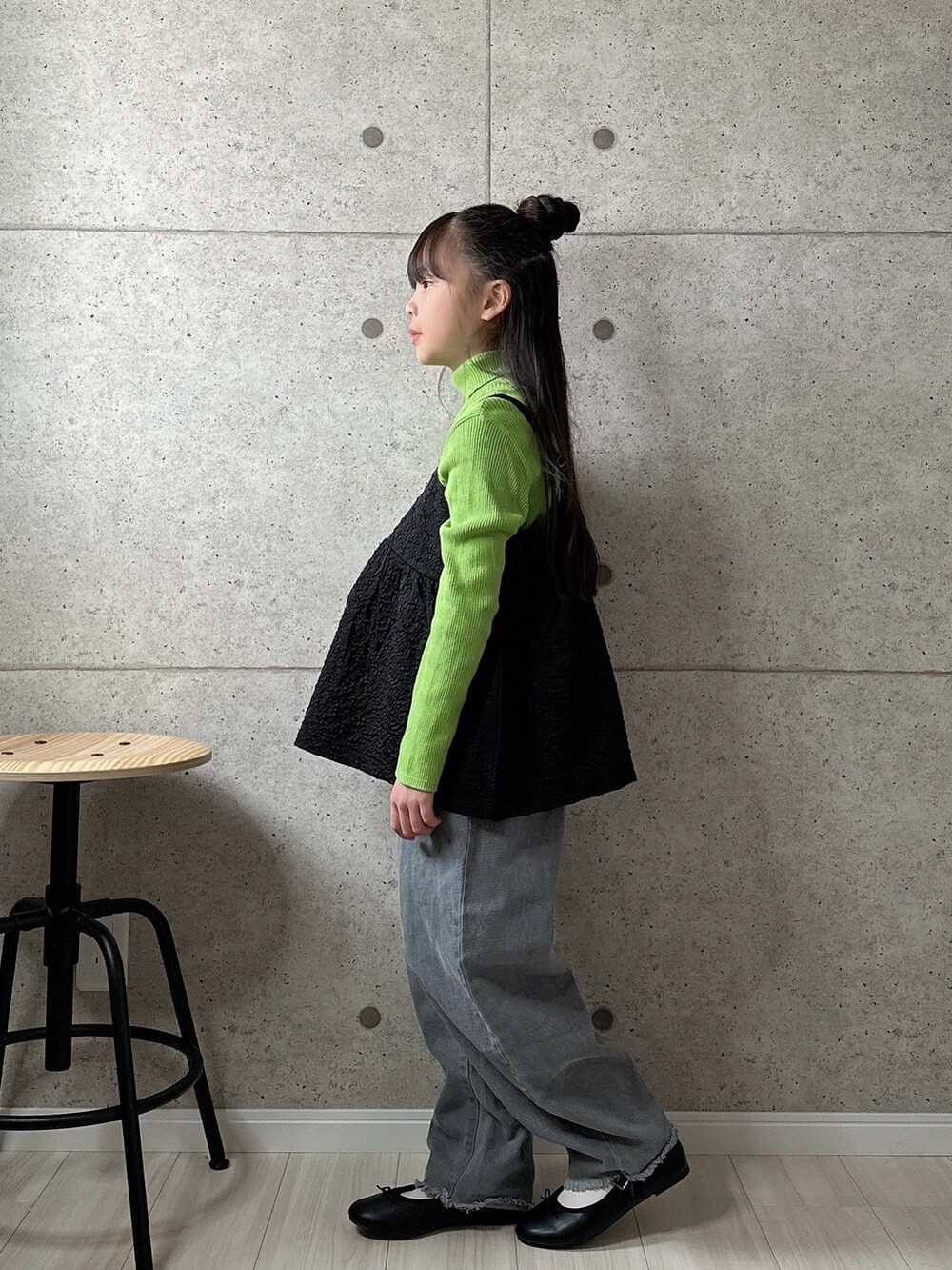 ブラック系のキャミソール、ブラック系のバレエシューズ、グレー系のデニムパンツを着用したキッズの冬コーディネートの2枚目の写真