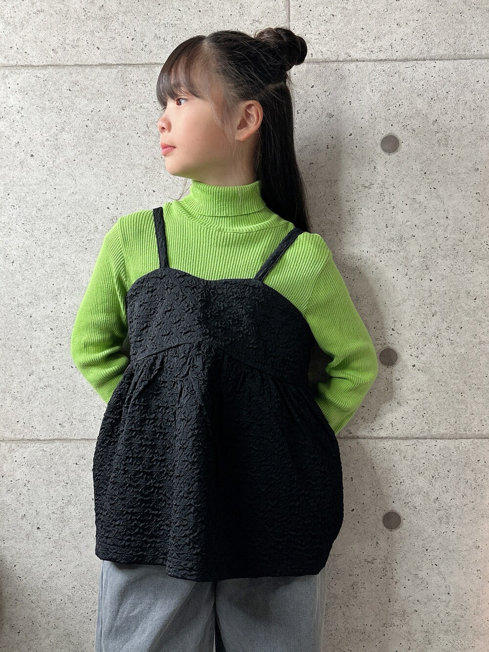 ブラック系のキャミソール、ブラック系のバレエシューズ、グレー系のデニムパンツを着用したキッズの冬コーディネートの4枚目の写真